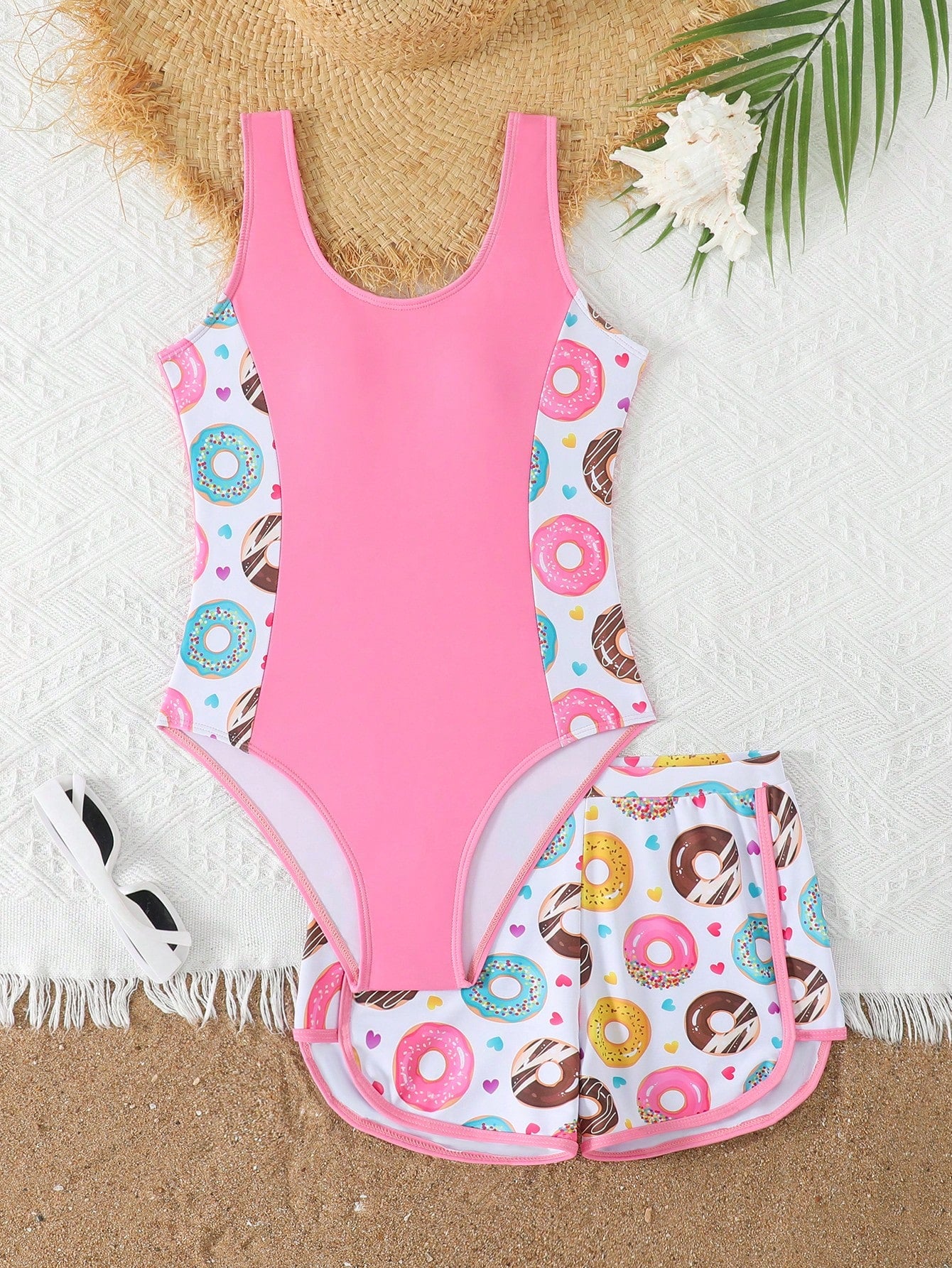 Tween girls 2-piece swimsuit set in black with full floral and plant print, featuring a sleeveless scoop-neck swim top and matching shorts-style bottoms.