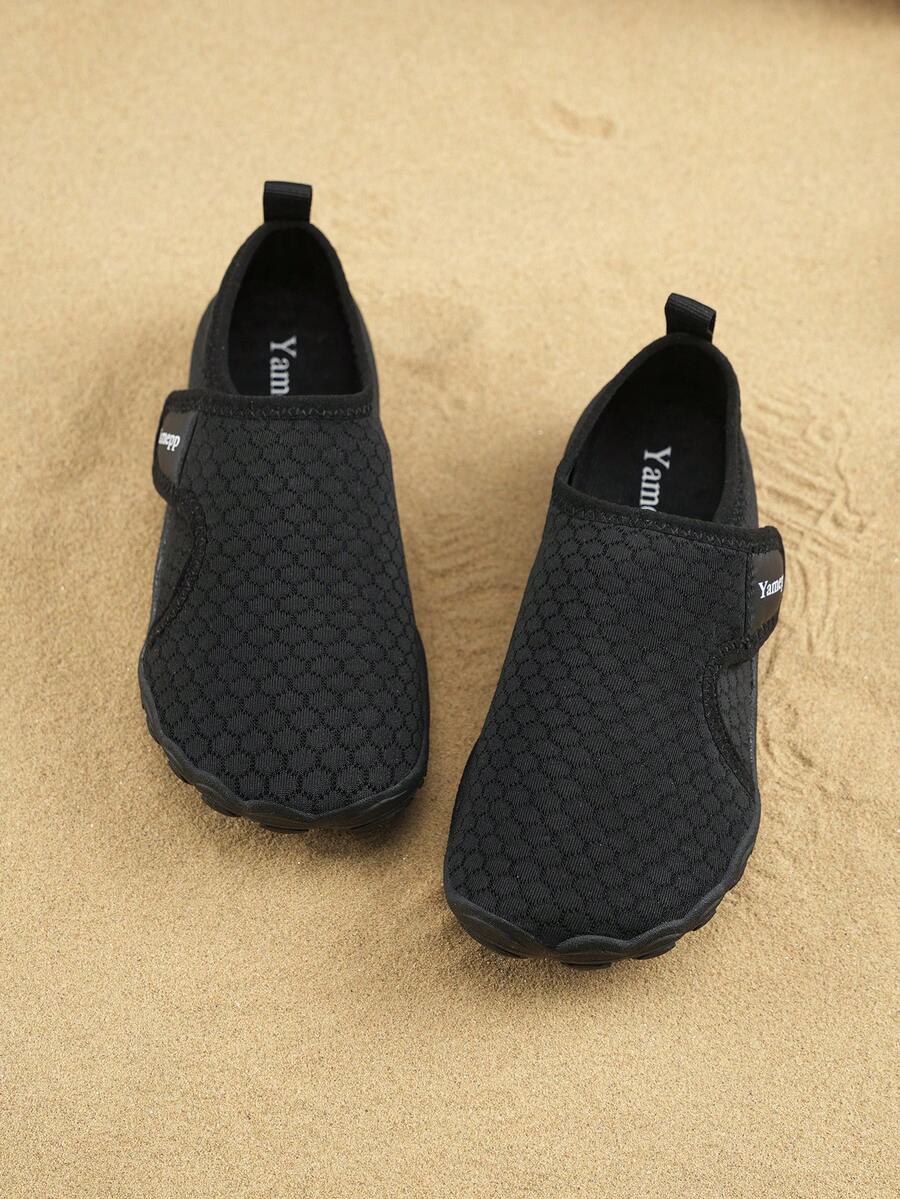 Black low-top kids water shoes featuring a breathable fabric upper, hook and loop closure, and rubber outsole for boys and girls.