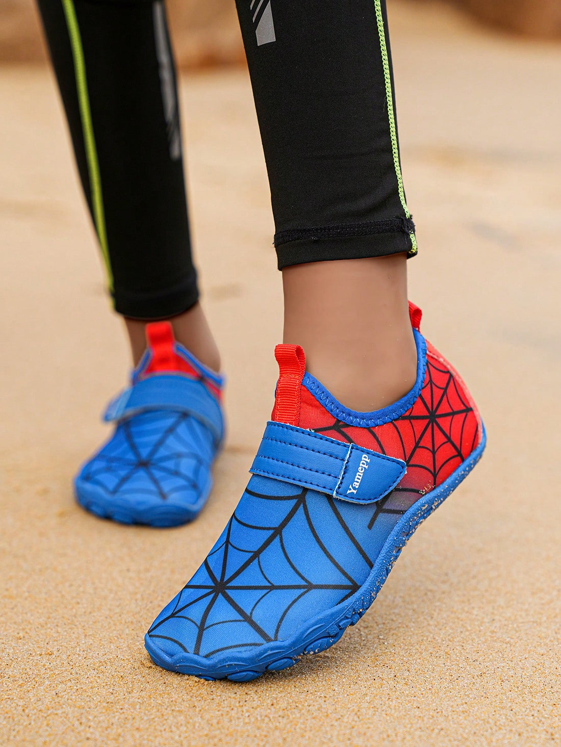 Pair of boys blue water shoes featuring a spider web mesh design, hook and loop strap, and non-slip rubber outsole.