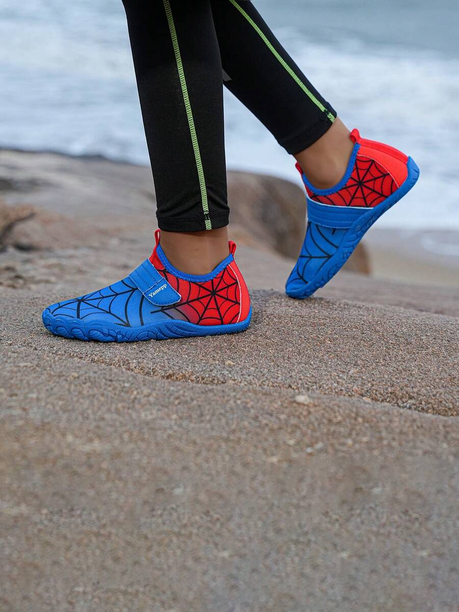 Pair of boys blue water shoes featuring a spider web mesh design, hook and loop strap, and non-slip rubber outsole.