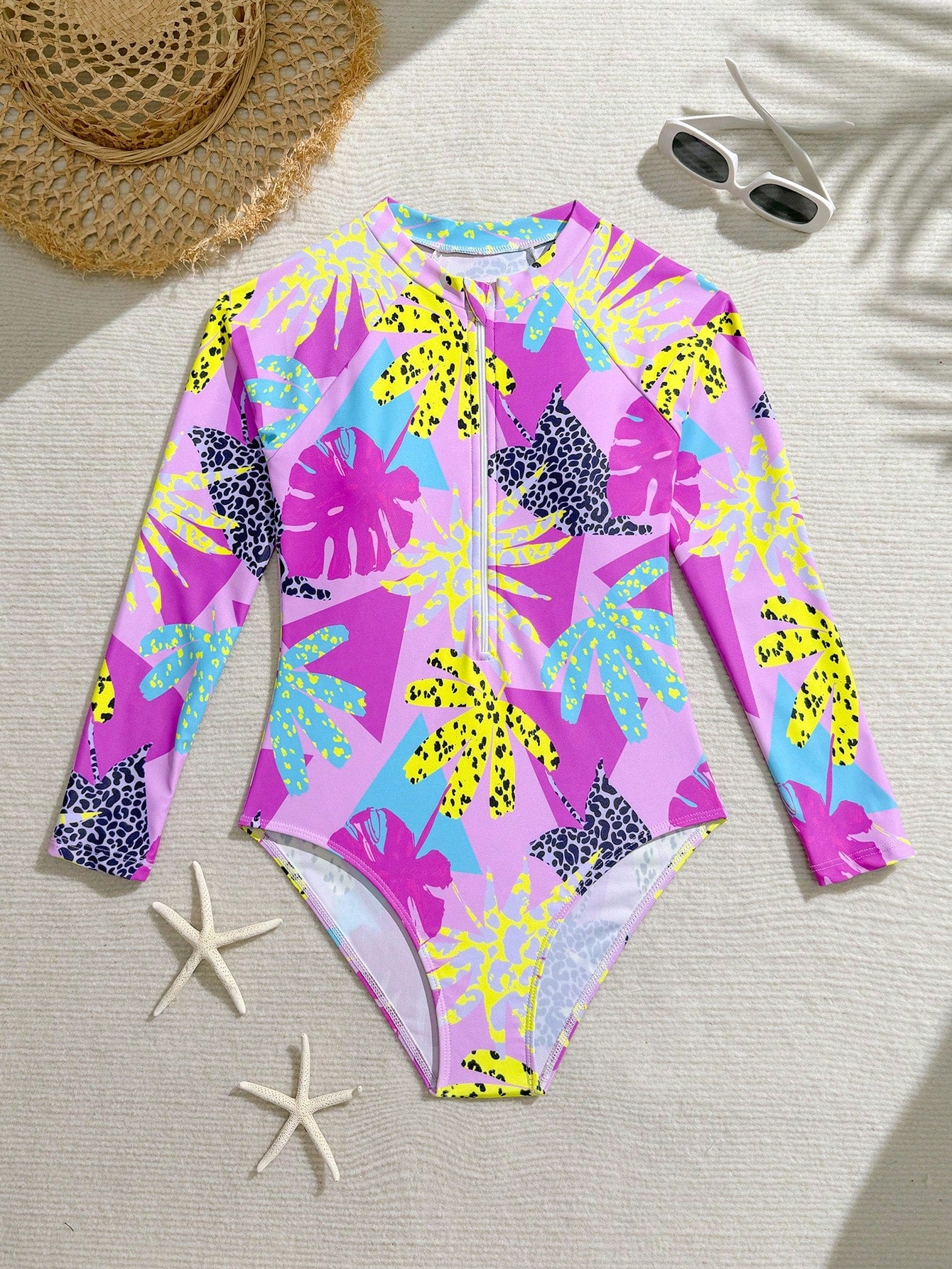 Girls one-piece swimsuit in blue with all-over leopard leaf print, ruffle detail, zipper front, high neck, and lined body for swimming and vacation.
