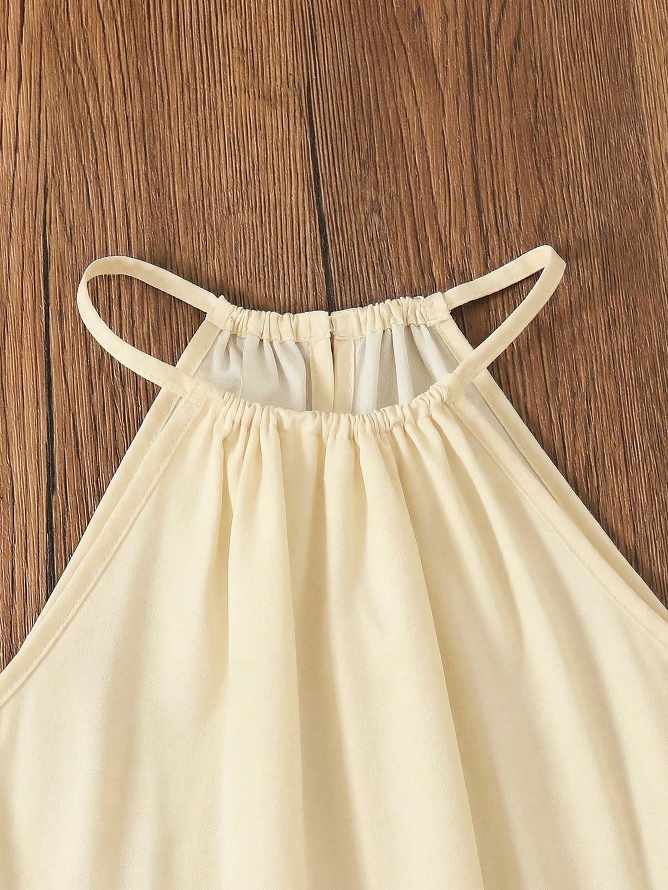 Tween girls floral print dress with halter neckline, sleeveless cold shoulder design, A-line shape, and vacation style.