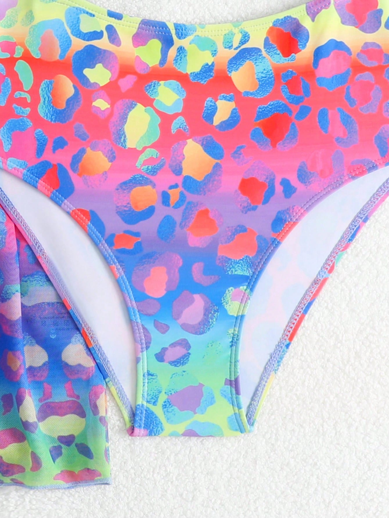 Tween girls multicolor 2-piece swimsuit set with scoop neck, cut-out details, patterned design, shorts-style bottoms, and sheer UV protection cover-up for beach and pool vacations.