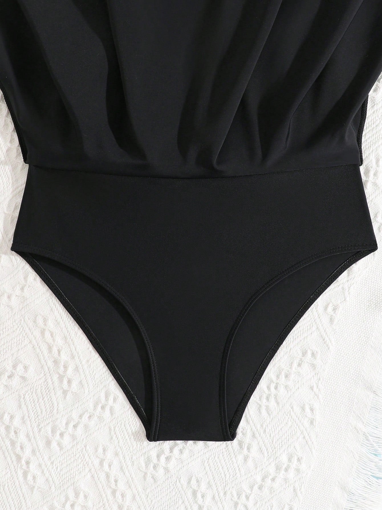 Tween girls one-piece swimsuit in black floral pattern with long sleeves, high neck, front zipper, and a skirt-style bottom.