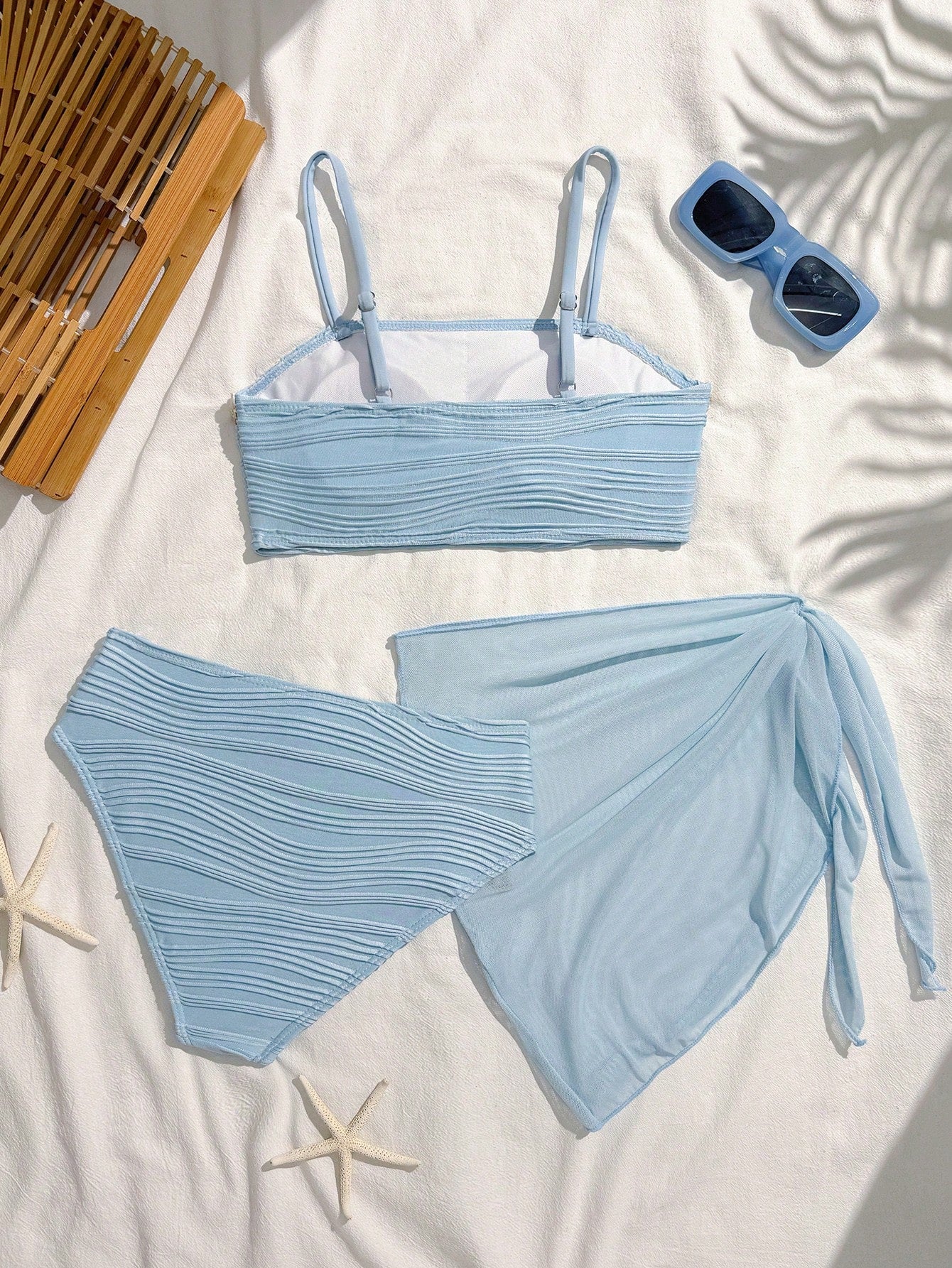 Tween girls bikini set with shell and starfish woven band details, spaghetti strap sleeveless top, and mid-waist skirt-style bottom in blue.