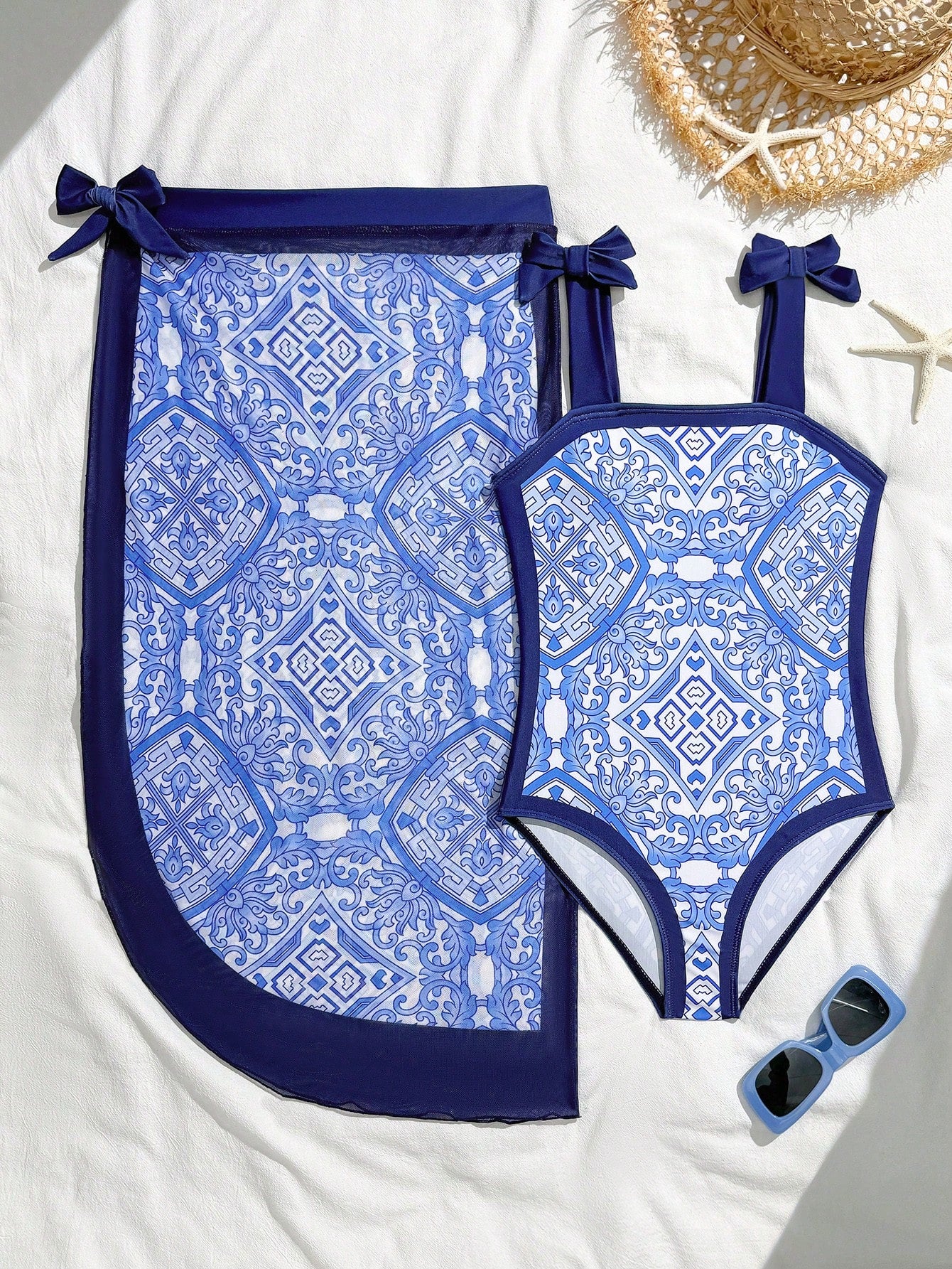 Tween girl black floral one-piece swimsuit set with spaghetti straps, asymmetrical detail, bow decor, and mid-waist bottom for beach, pool, and summer vacation wear.