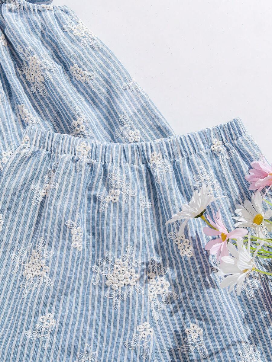 Tween girl wearing a blue and white striped sleeveless top featuring embroidery details and ruffle trim with matching shorts.