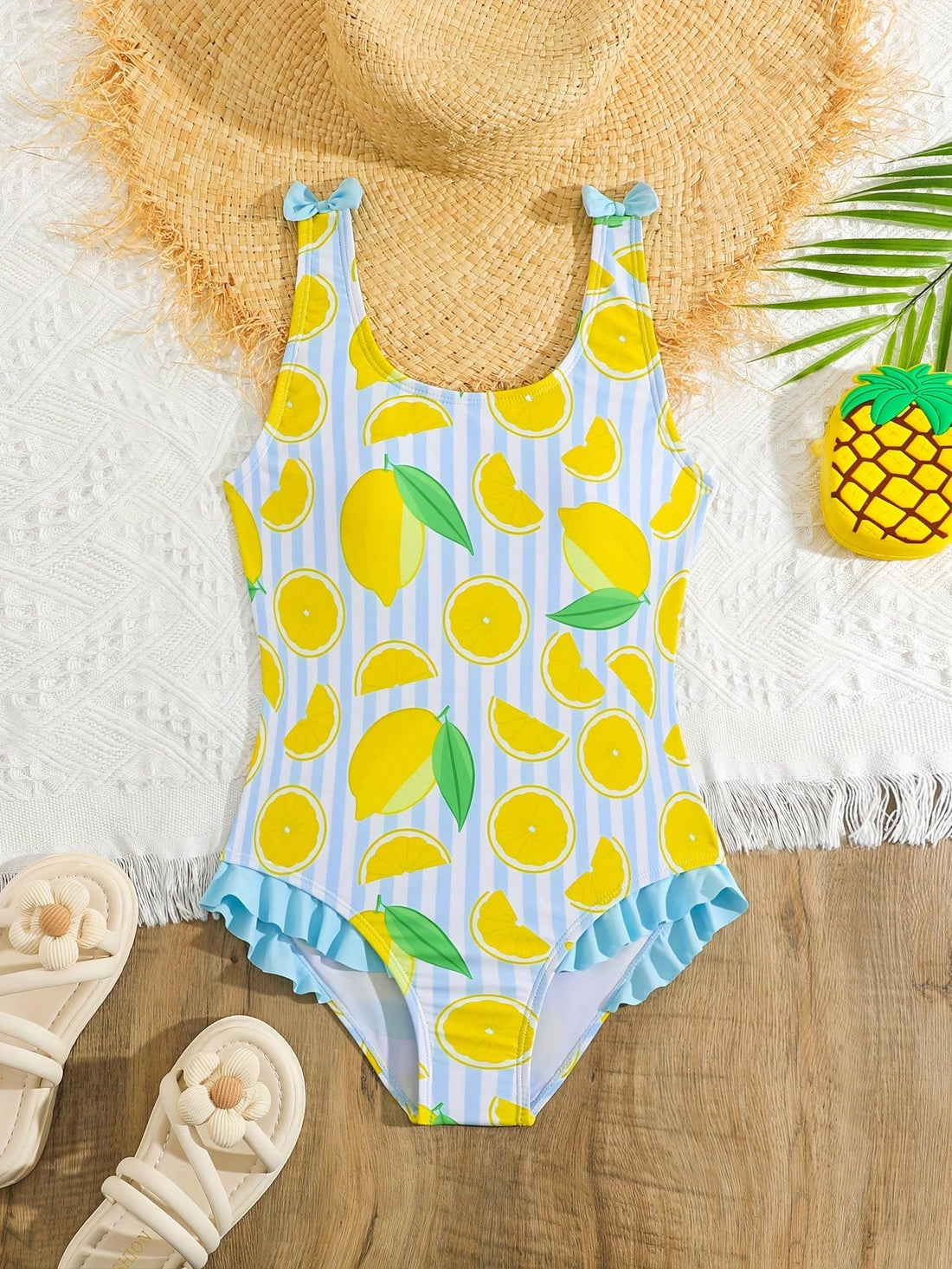 Tween girls purple one-piece swimsuit with lemon stripe pattern, spaghetti straps, ruffle detail, bow design, scoop neckline, and fitted swimwear shape
