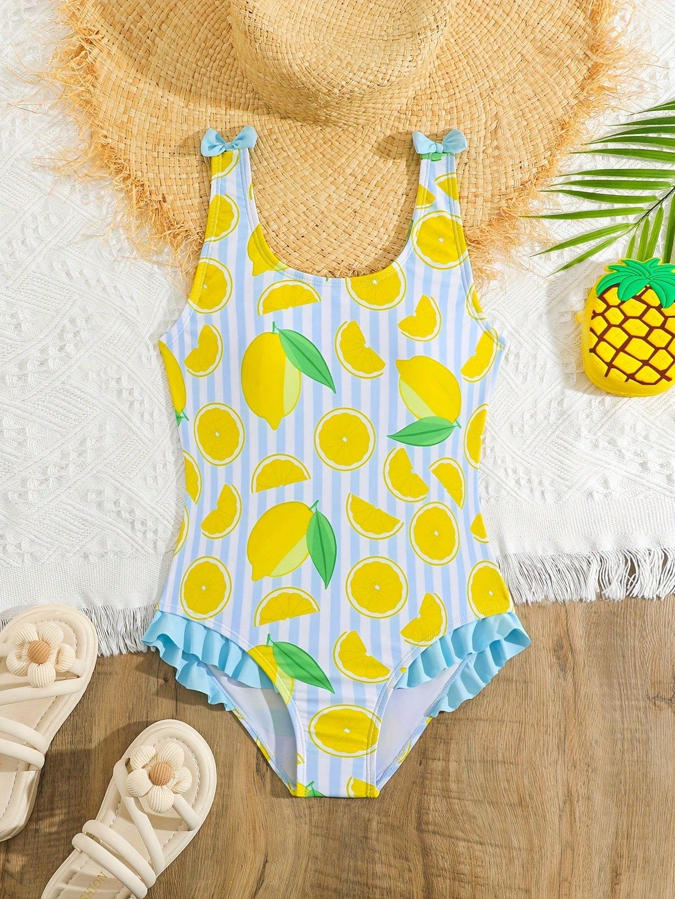 Tween girls purple one-piece swimsuit with lemon stripe pattern, spaghetti straps, ruffle detail, bow design, scoop neckline, and fitted swimwear shape