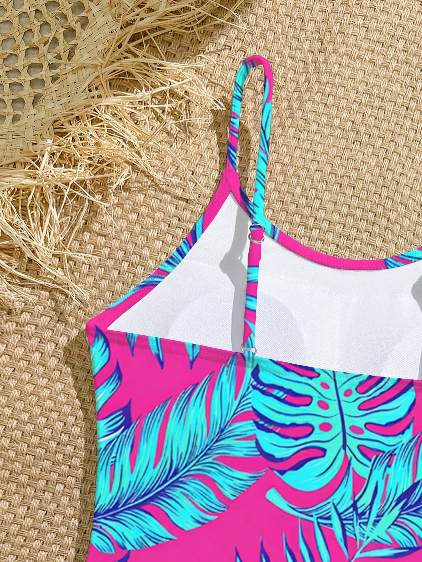 Tween girls one-piece swimsuit with a floral plant print, spaghetti straps, and a mid-waist fit in black.