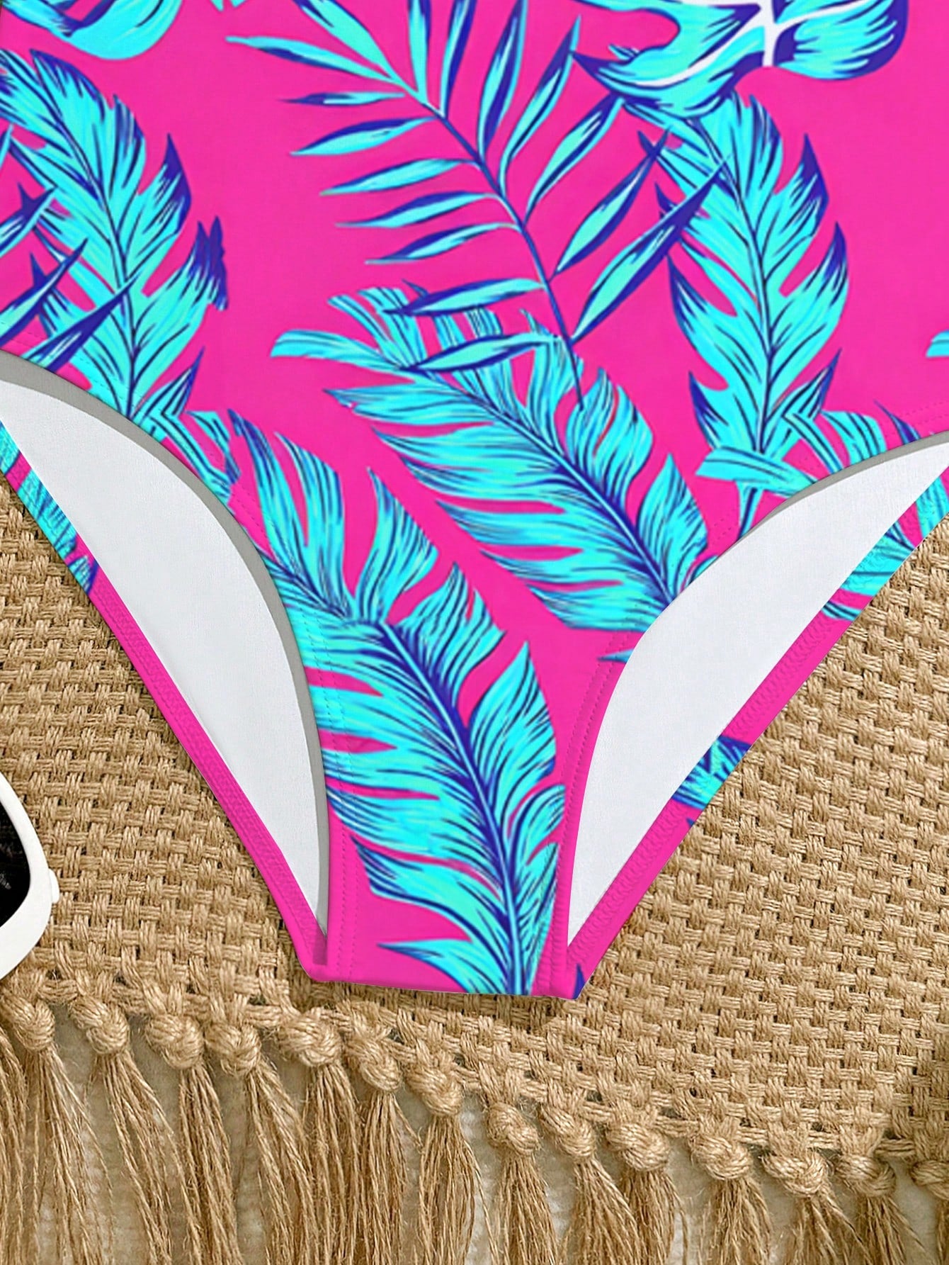 Tween girls one-piece swimsuit with a floral plant print, spaghetti straps, and a mid-waist fit in black.