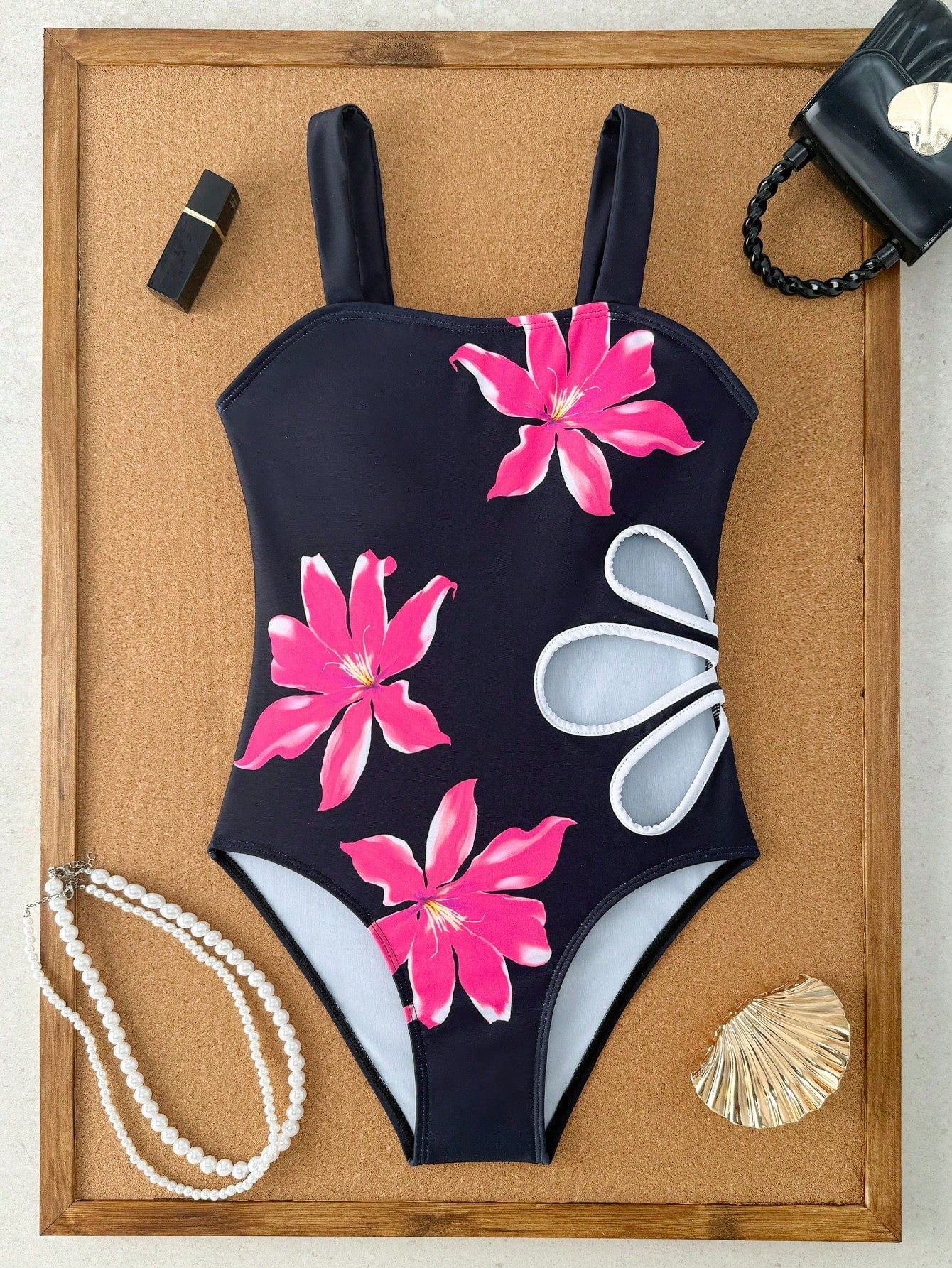 Tween girls one-piece swimsuit with a floral plant print, spaghetti straps, and a mid-waist fit in black.