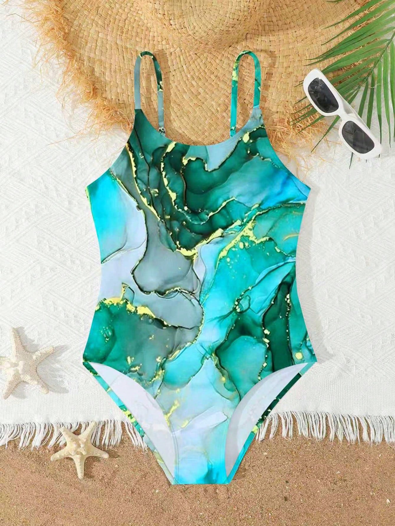 Tween girls one-piece swimsuit with multicolor ocean shell and seahorse all-over print, spaghetti straps, cut-out detail, and lined body for beach or swimming.