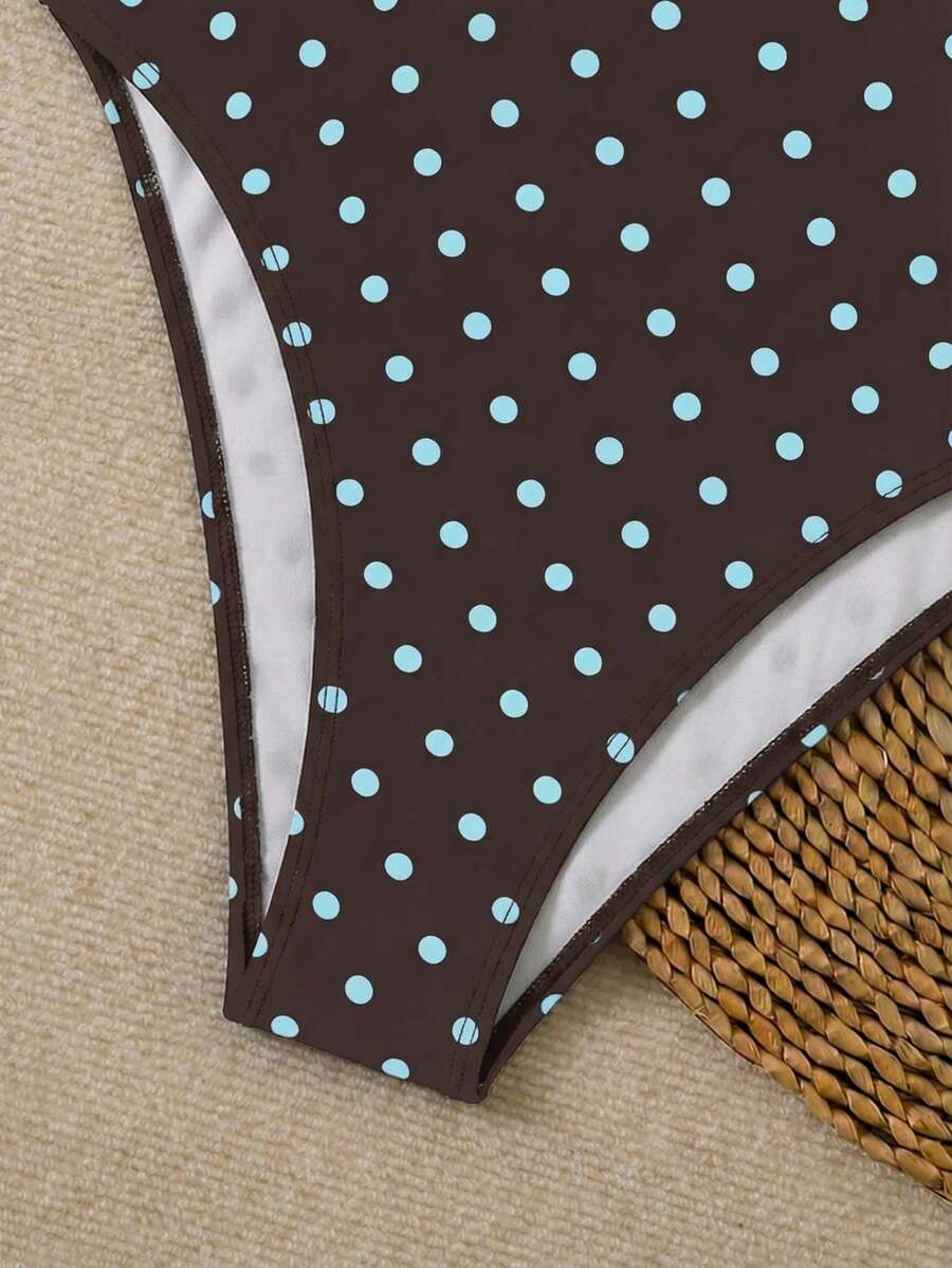 Women's apricot polka dot two-piece swimsuit featuring an asymmetrical halter backless top with knot tie detail and high-waisted bottoms.