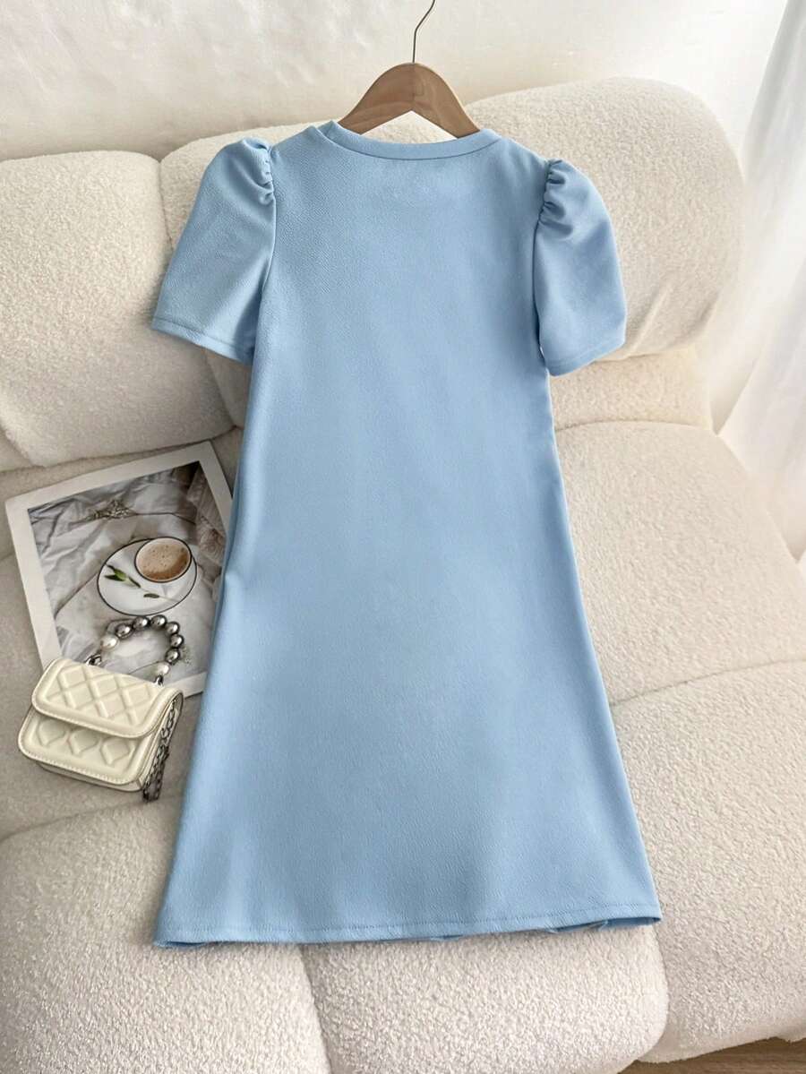 Tween girls apricot short-sleeve pleated smock dress with 3D bow decor and round neckline.