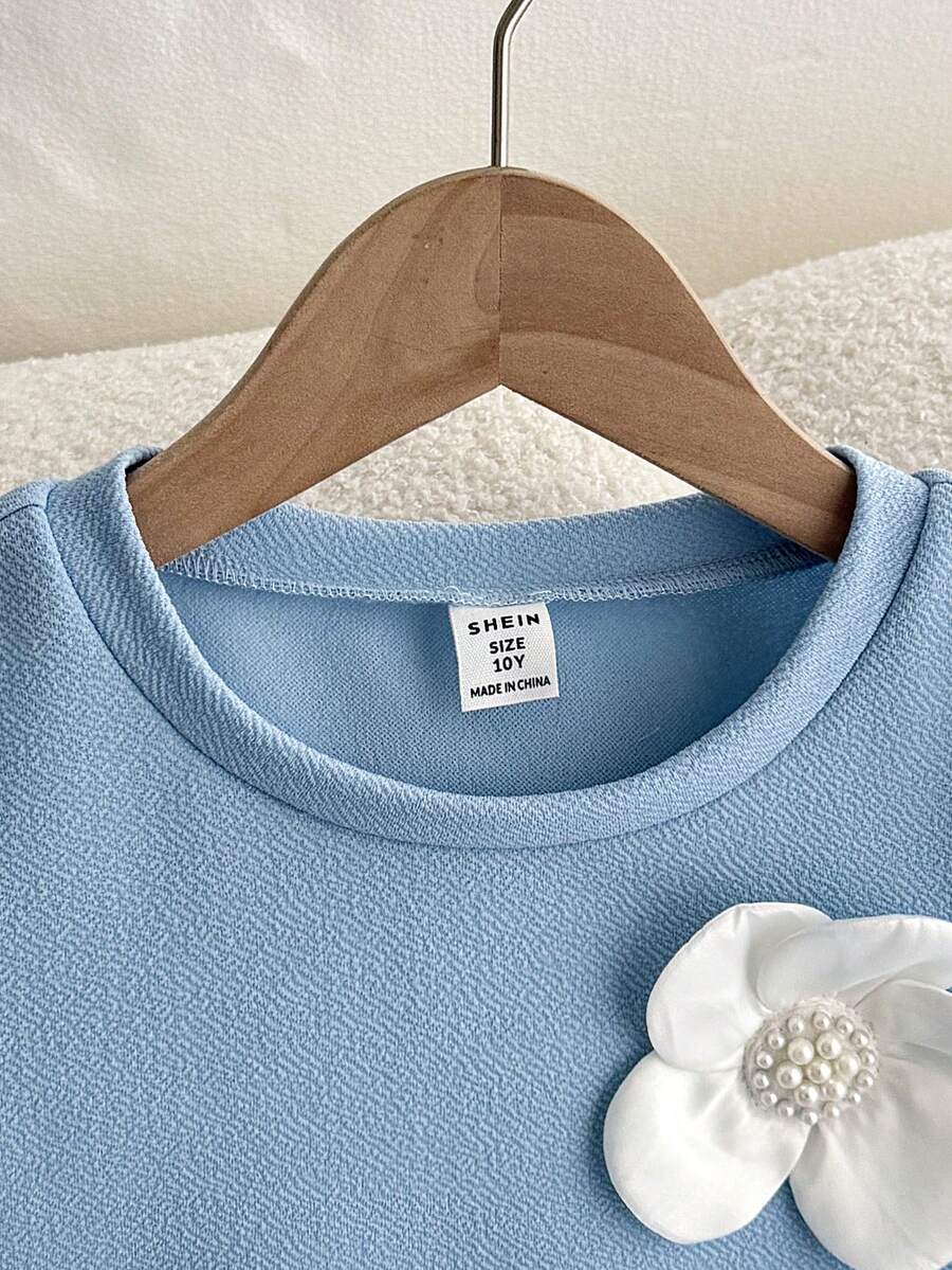 Tween girls apricot short-sleeve pleated smock dress with 3D bow decor and round neckline.