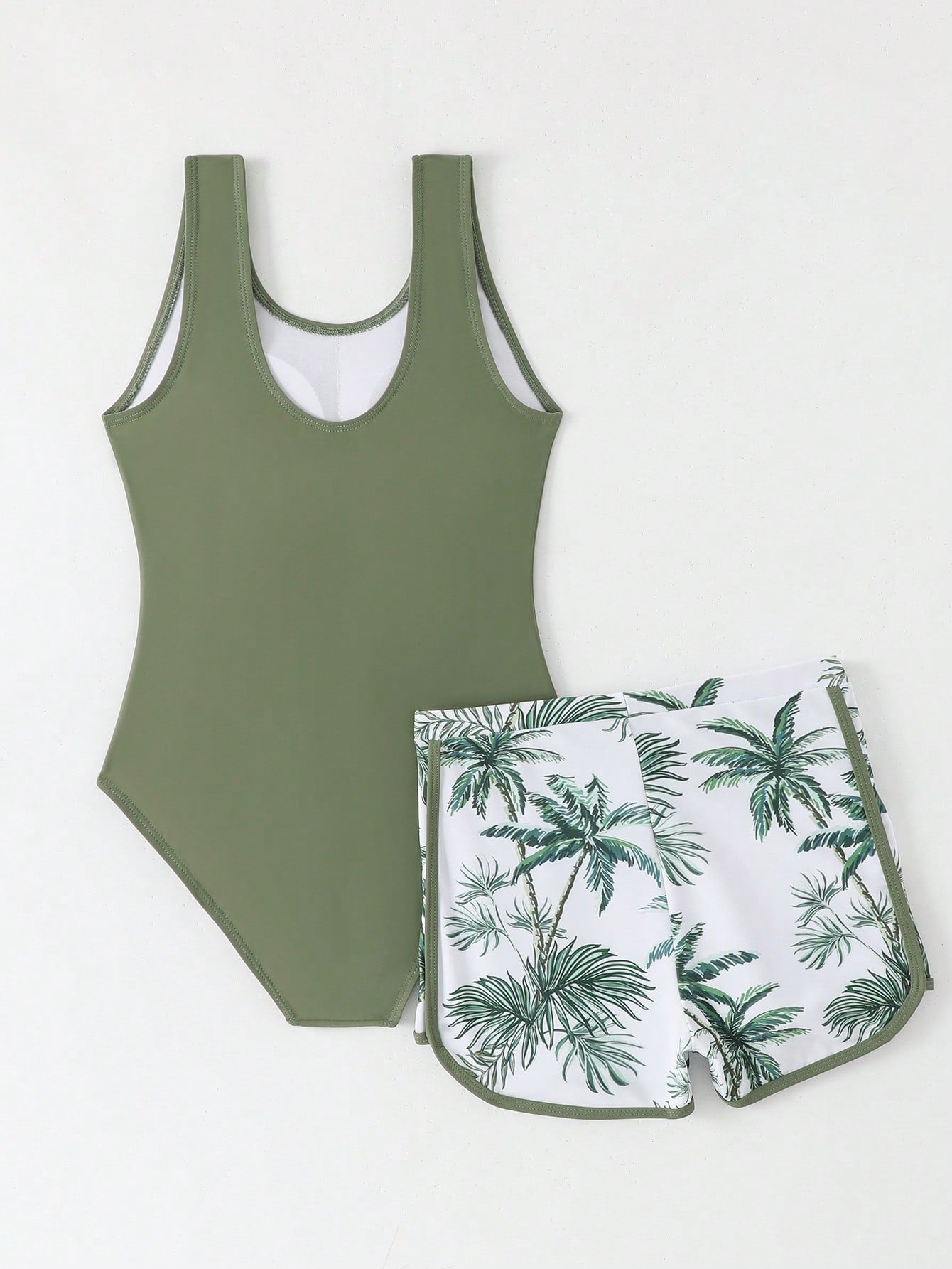 Tween girls 2-piece swimsuit set in black with full floral and plant print, featuring a sleeveless scoop-neck swim top and matching shorts-style bottoms.