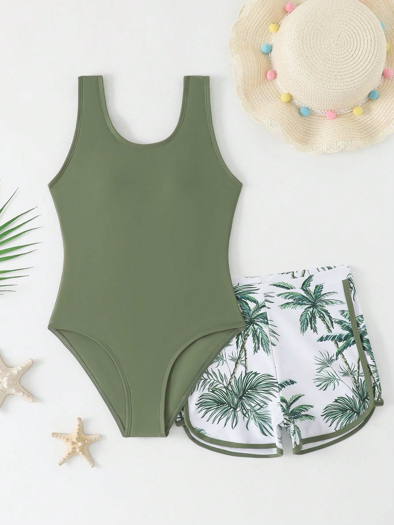 Tween girls 2-piece swimsuit set in black with full floral and plant print, featuring a sleeveless scoop-neck swim top and matching shorts-style bottoms.