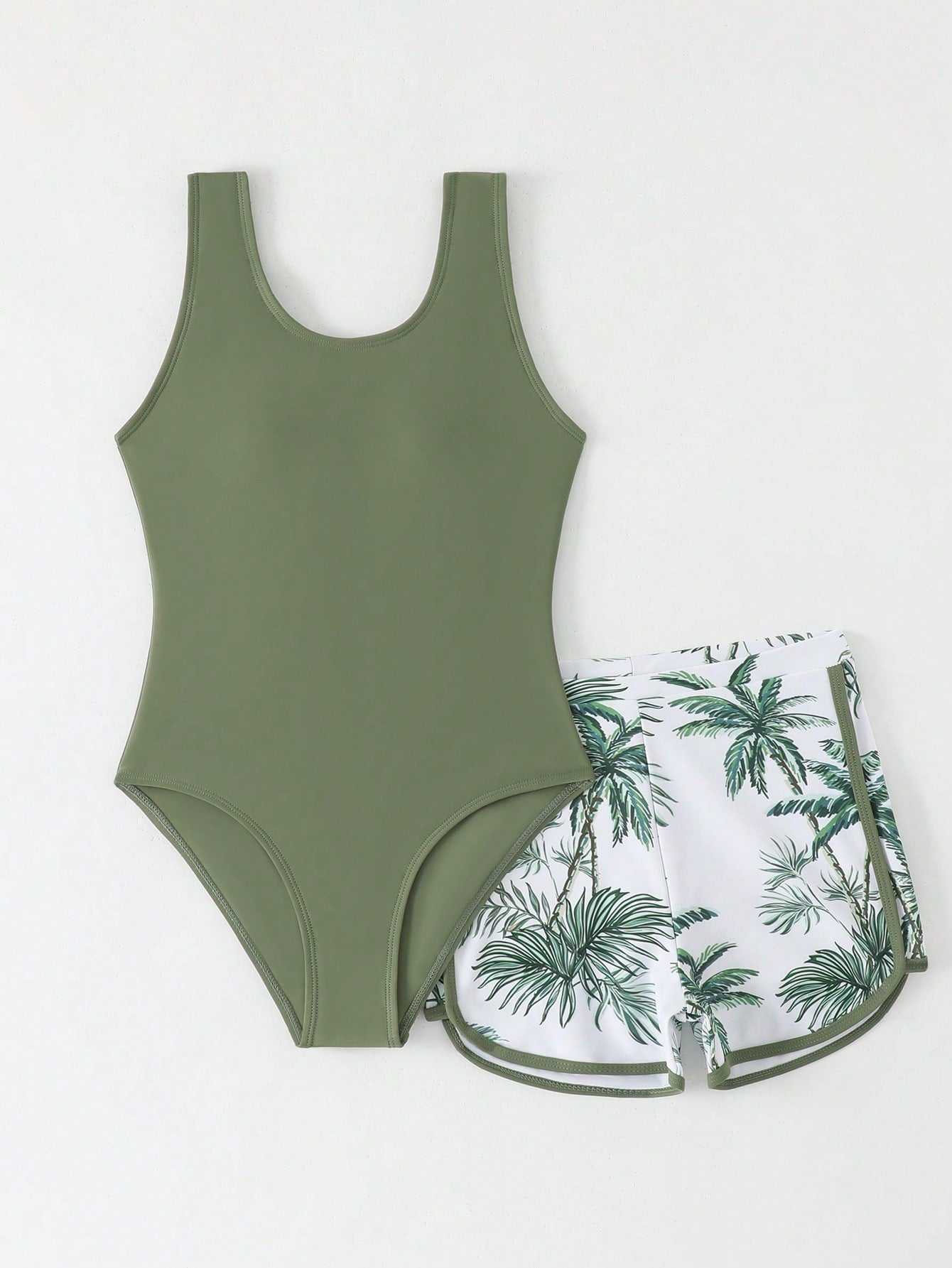 Tween girls 2-piece swimsuit set in black with full floral and plant print, featuring a sleeveless scoop-neck swim top and matching shorts-style bottoms.