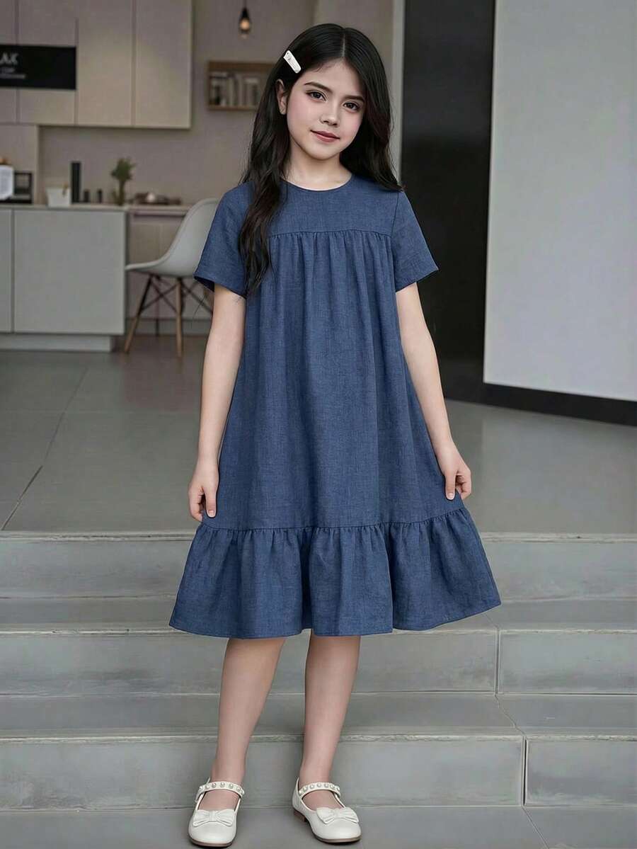 Tween girl wearing an Army Green textured short sleeve smock midi dress with round neck and ruffle flounce hem.