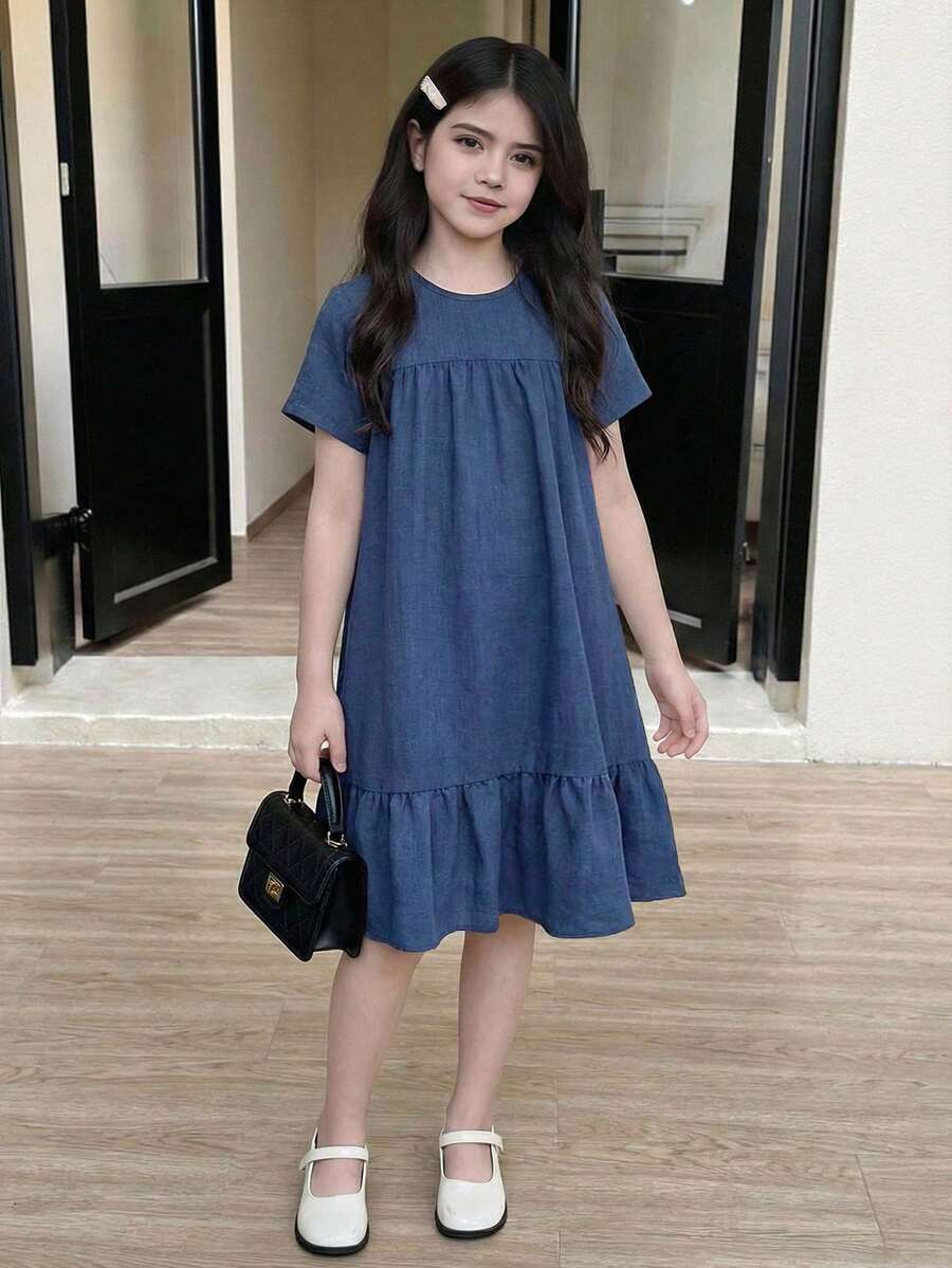 Tween girl wearing an Army Green textured short sleeve smock midi dress with round neck and ruffle flounce hem.