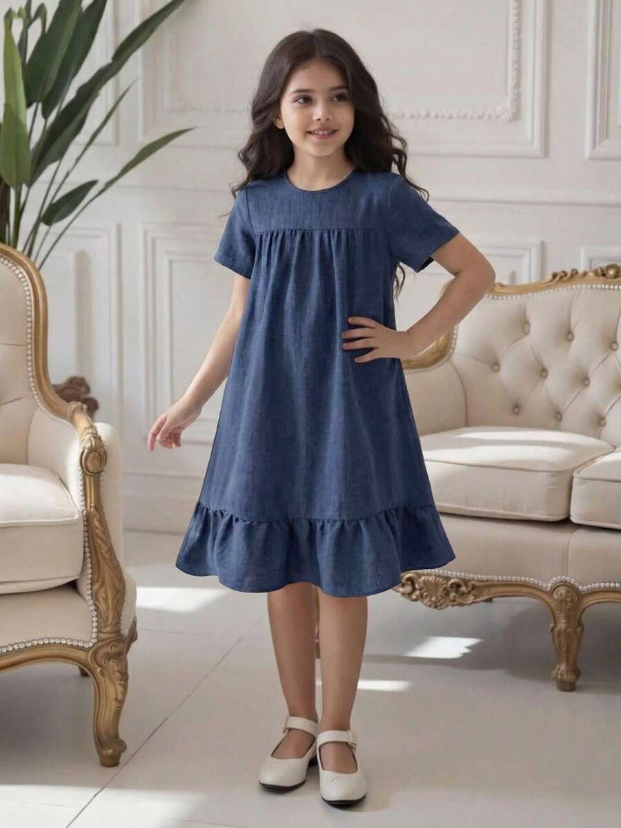 Tween girl wearing an Army Green textured short sleeve smock midi dress with round neck and ruffle flounce hem.