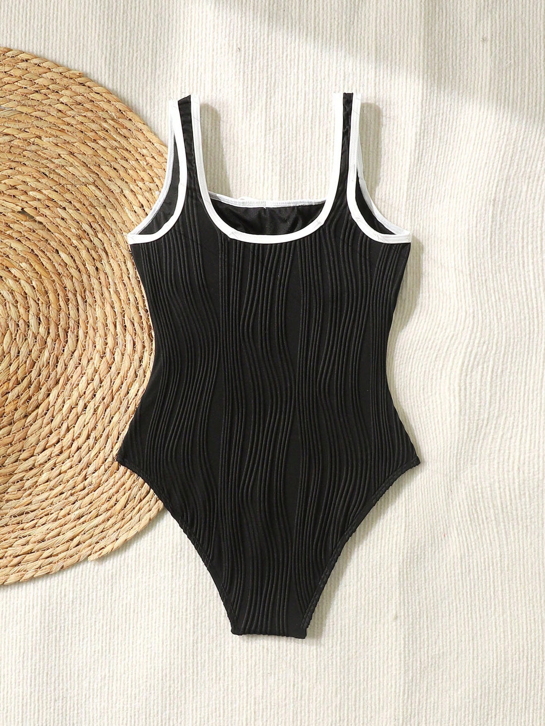 Tween girls black and white one-piece swimsuit with contrast piping, scoop neck, all-over print, and textured vacation style.