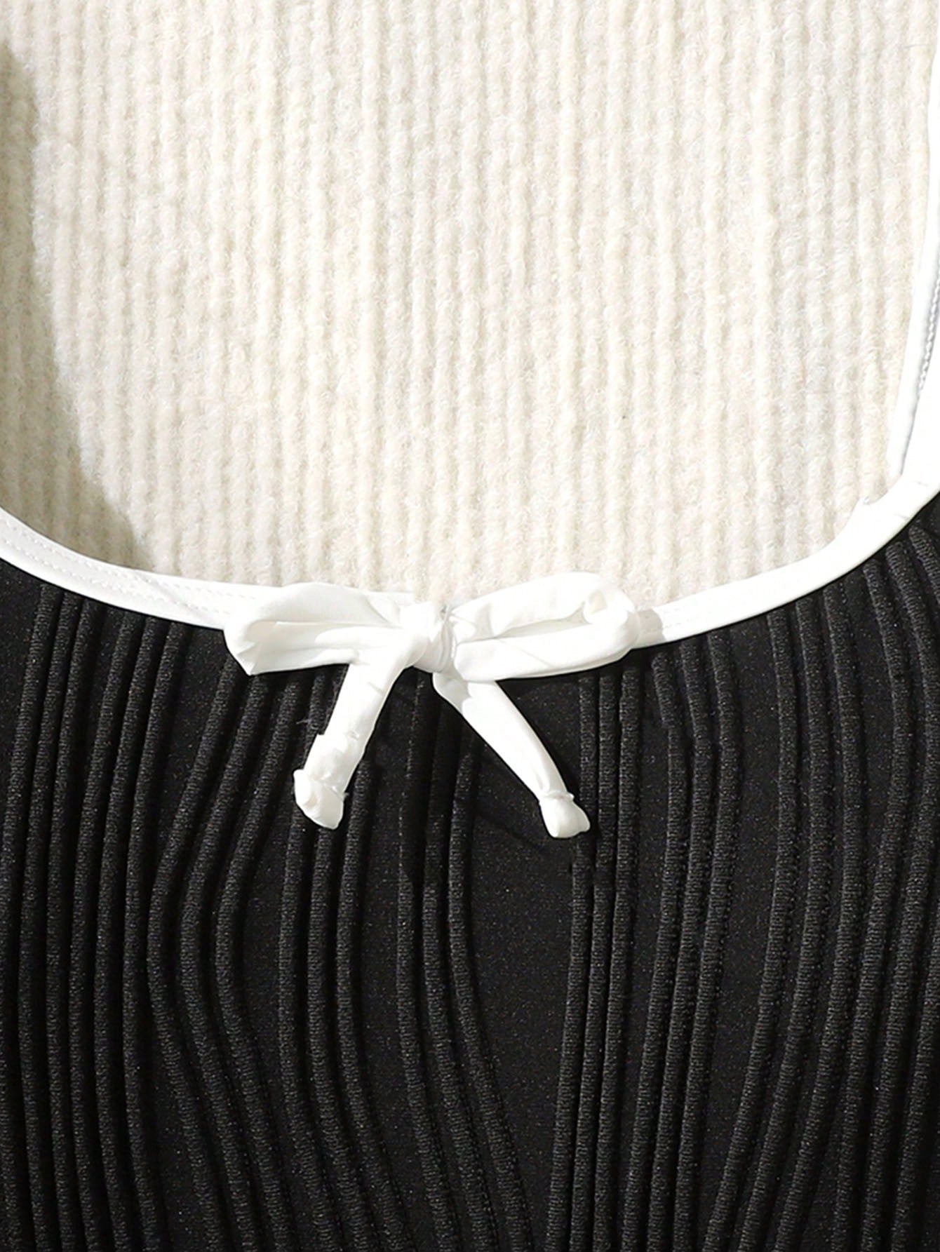Tween girls black and white one-piece swimsuit with contrast piping, scoop neck, all-over print, and textured vacation style.