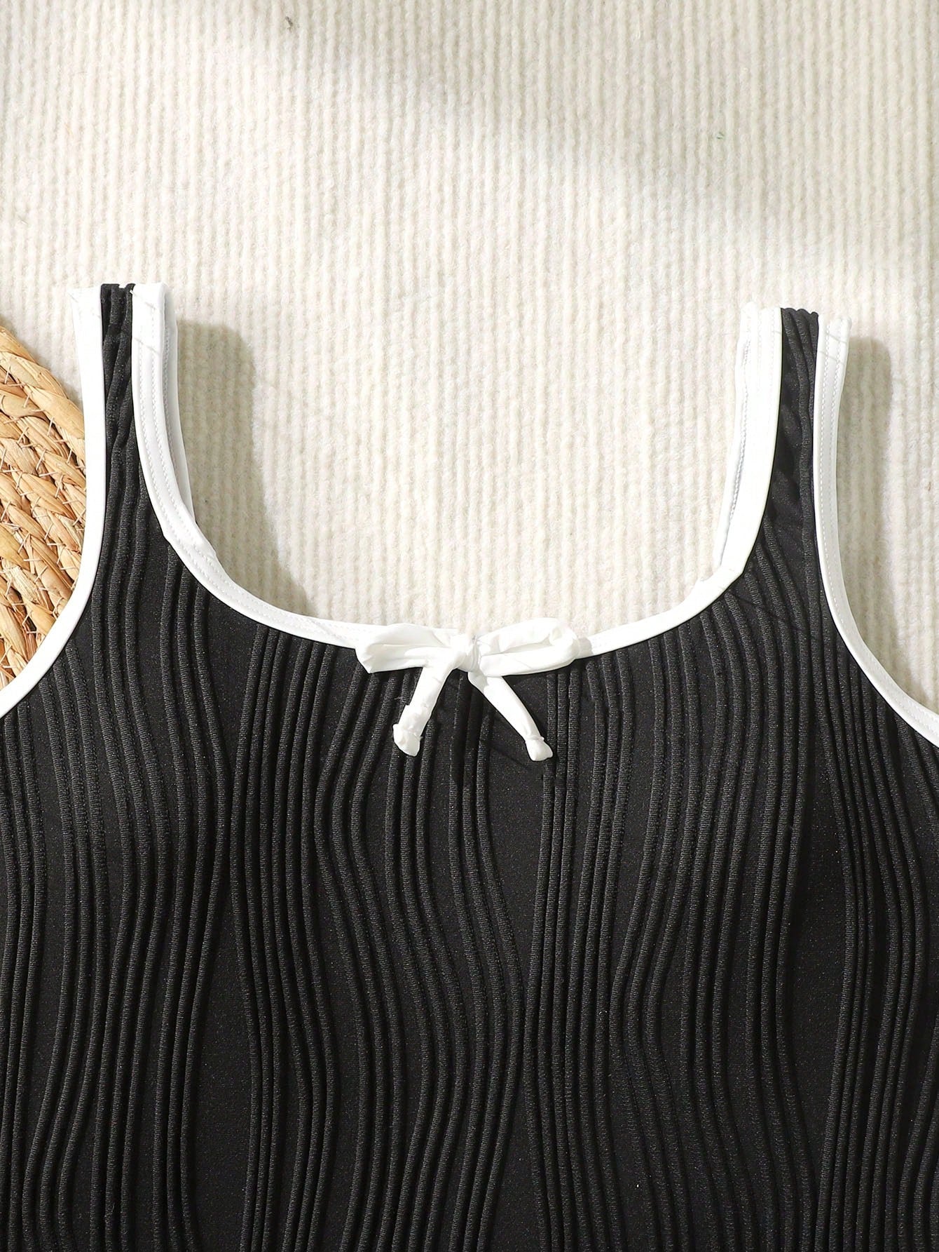 Tween girls black and white one-piece swimsuit with contrast piping, scoop neck, all-over print, and textured vacation style.