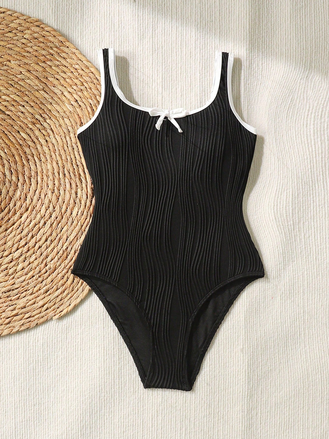 Tween girls black and white one-piece swimsuit with contrast piping, scoop neck, all-over print, and textured vacation style.