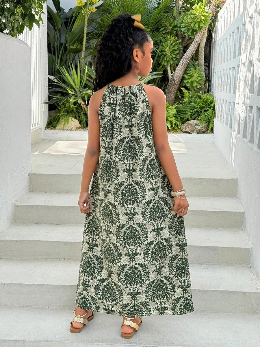 Tween girls green floral print cami dress with halter neckline, sleeveless cut, zipper detail, flared hem, and long vacation style silhouette.
