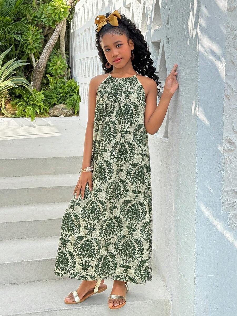Tween girls green floral print cami dress with halter neckline, sleeveless cut, zipper detail, flared hem, and long vacation style silhouette.