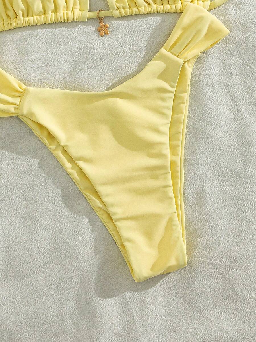 Women's solid yellow 2-piece bikini set featuring a high-waist bottom and a wireless bandeau top on display for beach and resort wear.