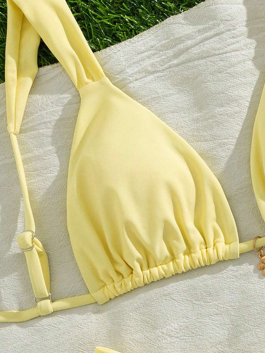 Women's solid yellow 2-piece bikini set featuring a high-waist bottom and a wireless bandeau top on display for beach and resort wear.