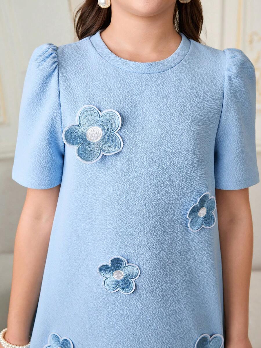 Tween girls apricot short-sleeve pleated smock dress with 3D bow decor and round neckline.