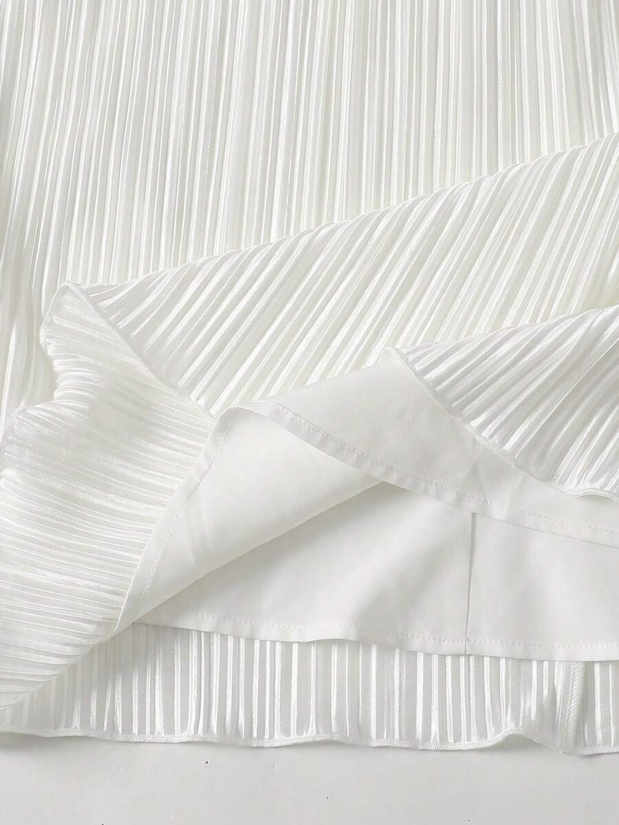 Tween girl wearing a white sleeveless pleated A-line short dress featuring a round neckline and button detail.