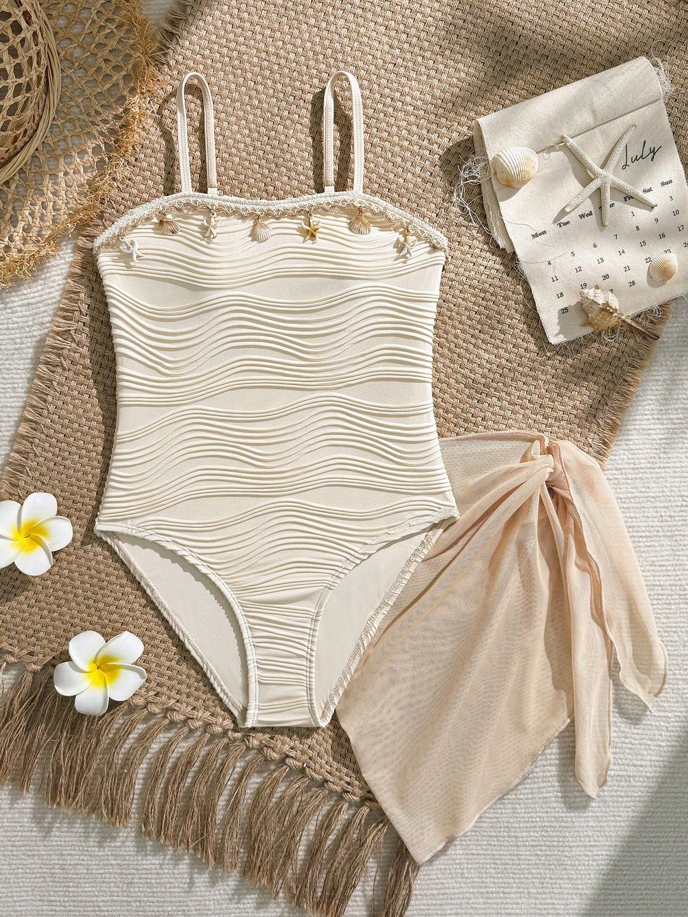 Blue girls one-piece swimsuit with spaghetti straps, textured plain fabric, shell-inspired detail, and matching skirt bottom for beach or pool vacation wear.