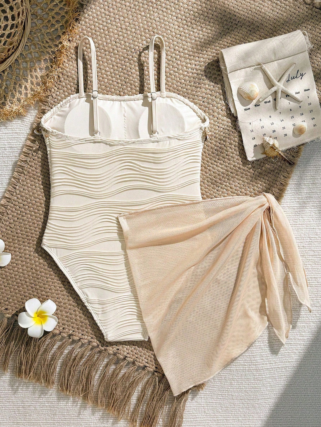 Blue girls one-piece swimsuit with spaghetti straps, textured plain fabric, shell-inspired detail, and matching skirt bottom for beach or pool vacation wear.
