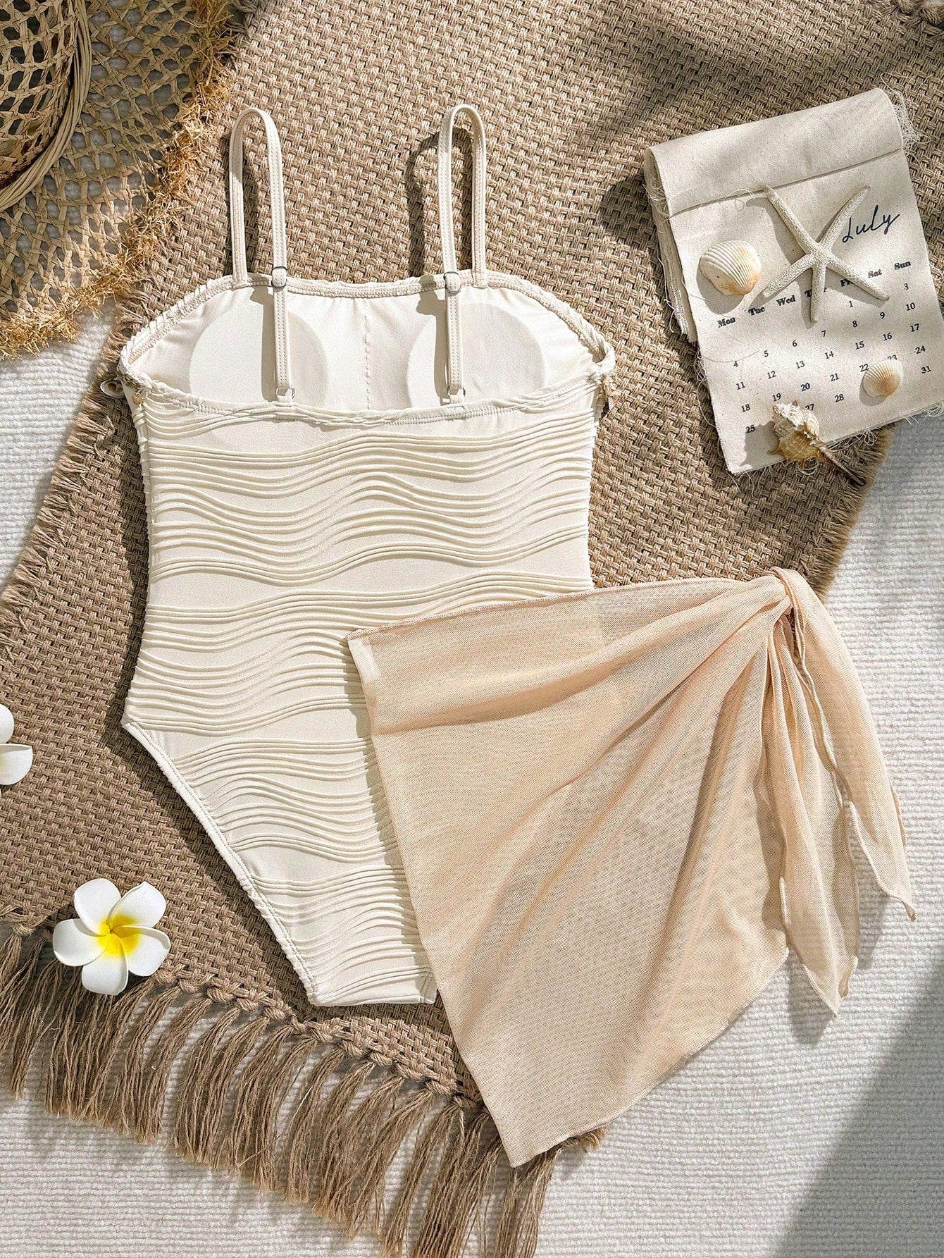 Blue girls one-piece swimsuit with spaghetti straps, textured plain fabric, shell-inspired detail, and matching skirt bottom for beach or pool vacation wear.