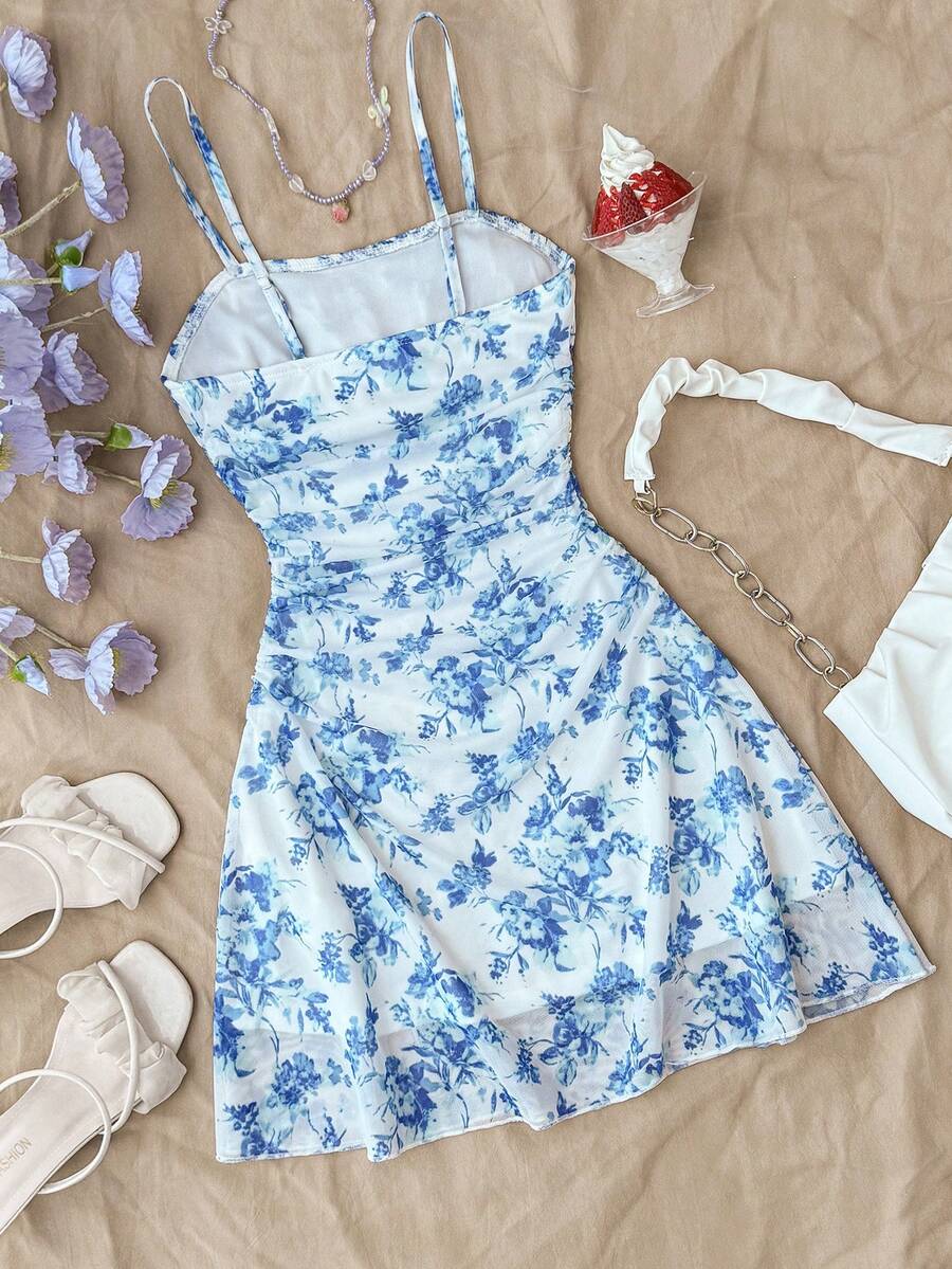 Tween girl yellow mini sundress with large pink floral hibiscus print, spaghetti straps, high waist, flared hem, and sleeveless cami style for summer beach wear