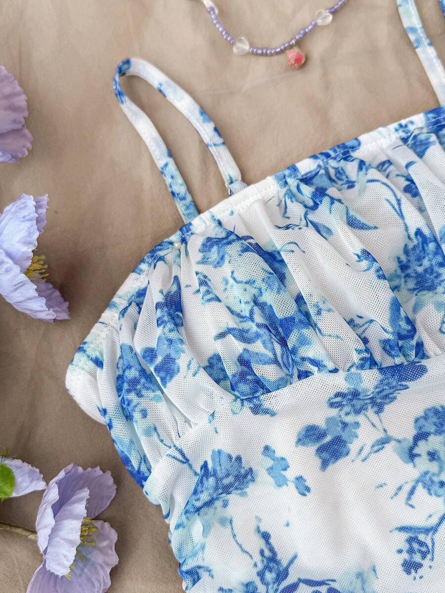 Tween girl yellow mini sundress with large pink floral hibiscus print, spaghetti straps, high waist, flared hem, and sleeveless cami style for summer beach wear