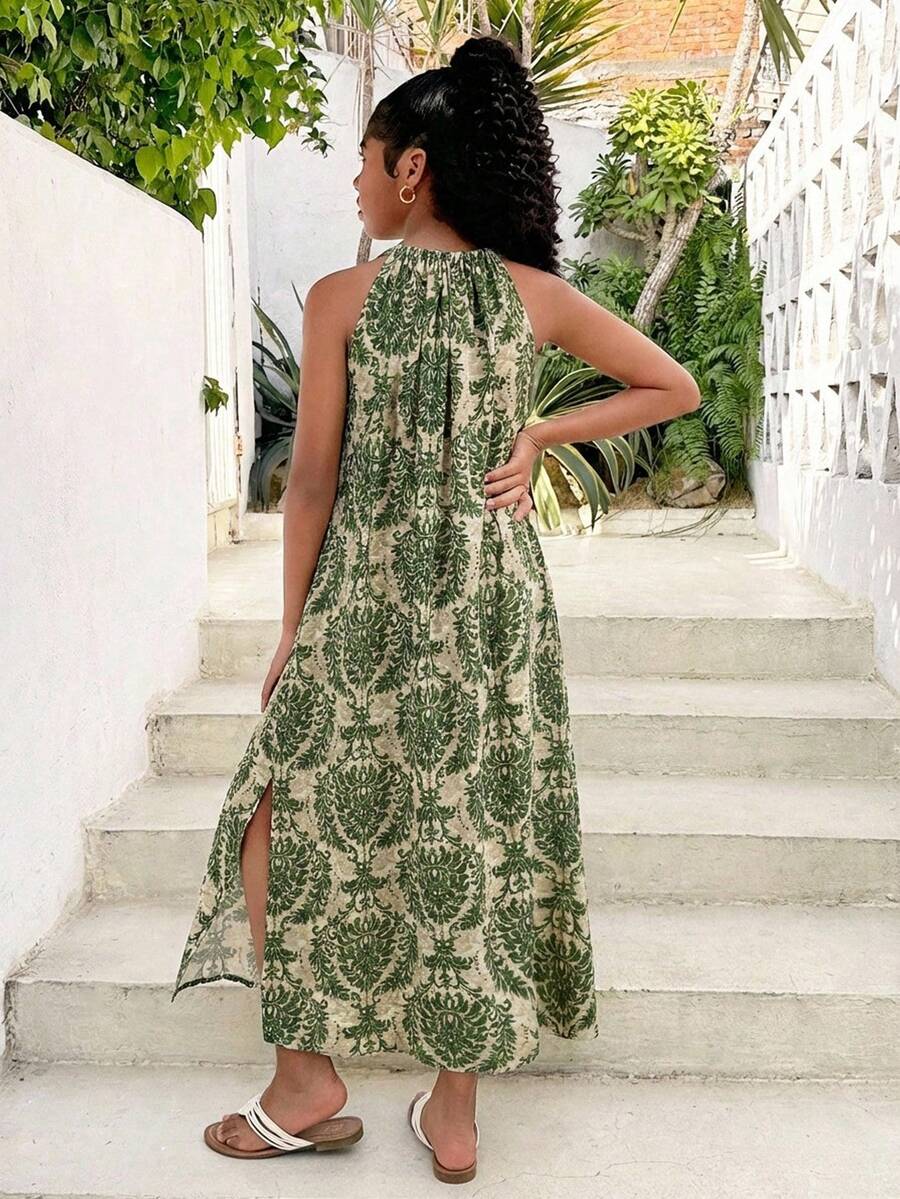 Tween girls green floral print cami dress with halter neckline, sleeveless cut, zipper detail, flared hem, and long vacation style silhouette.