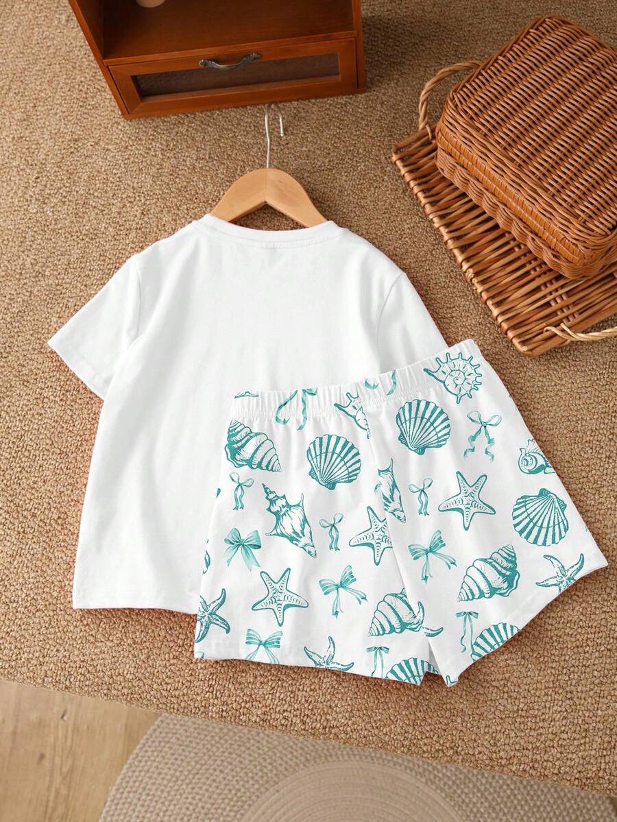 Teen girl wearing 2-piece summer vacation set with blue and white striped short sleeve top featuring seashell ocean bow print and matching loose fit shorts with pockets.