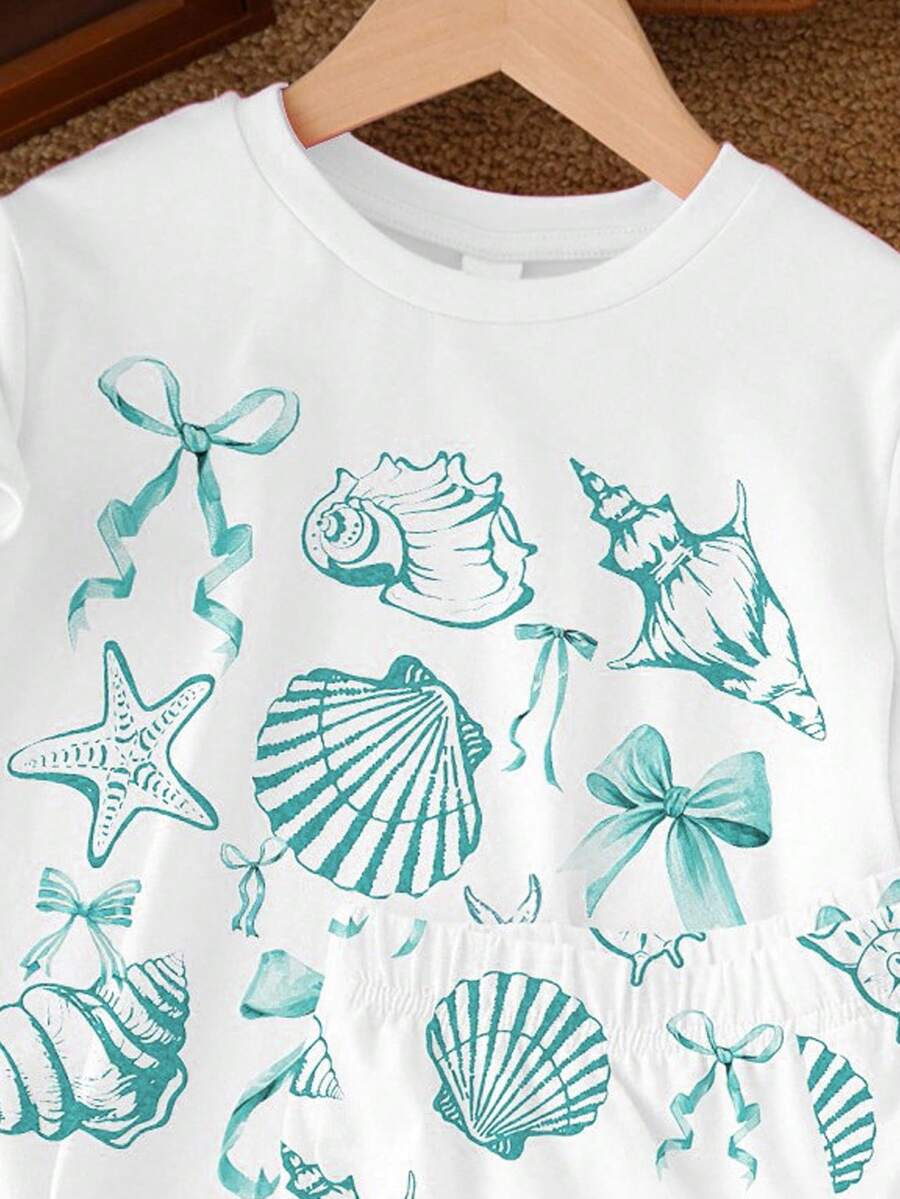 Teen girl wearing 2-piece summer vacation set with blue and white striped short sleeve top featuring seashell ocean bow print and matching loose fit shorts with pockets.