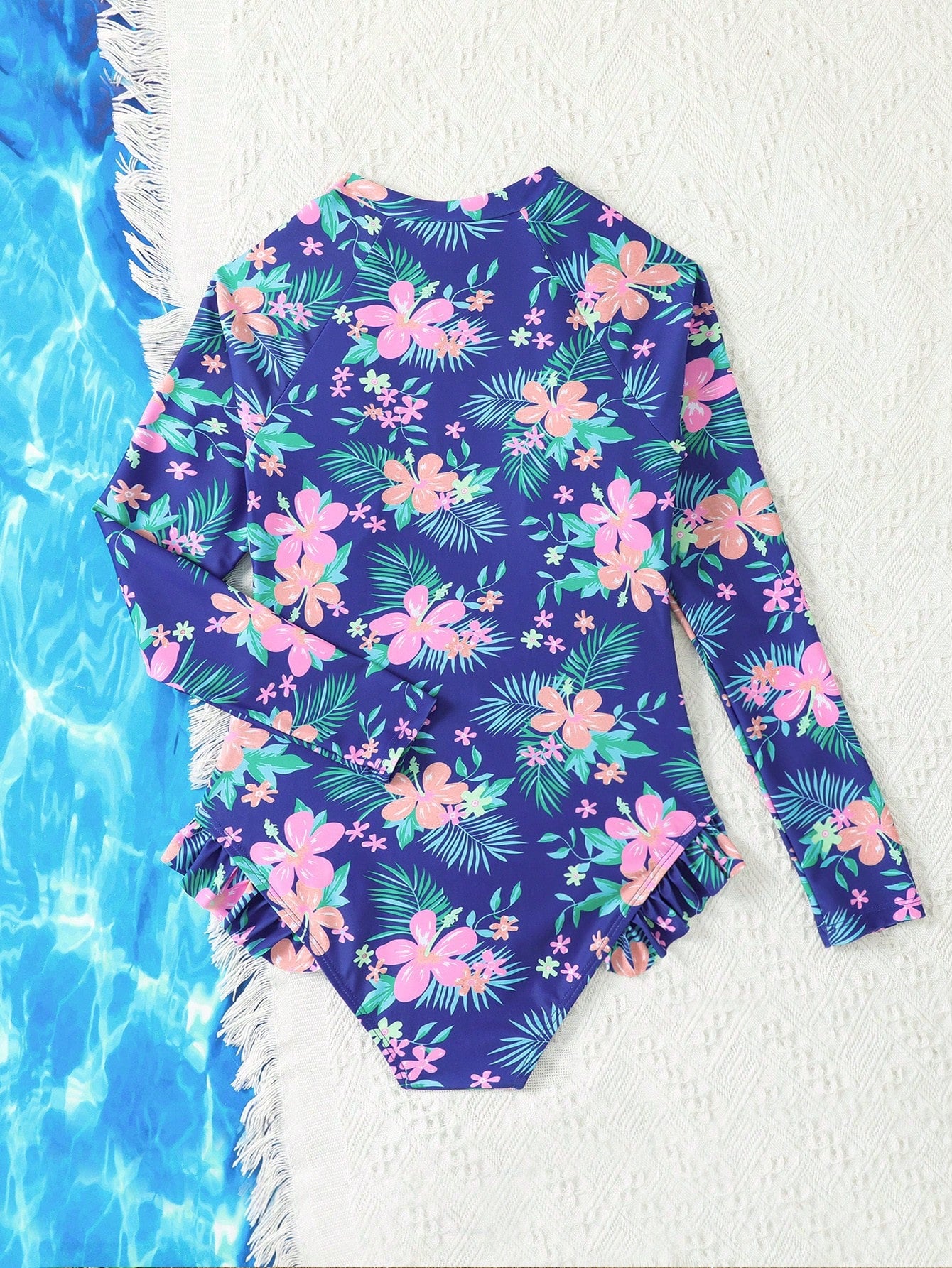 Girls one-piece swimsuit in blue with all-over leopard leaf print, ruffle detail, zipper front, high neck, and lined body for swimming and vacation.