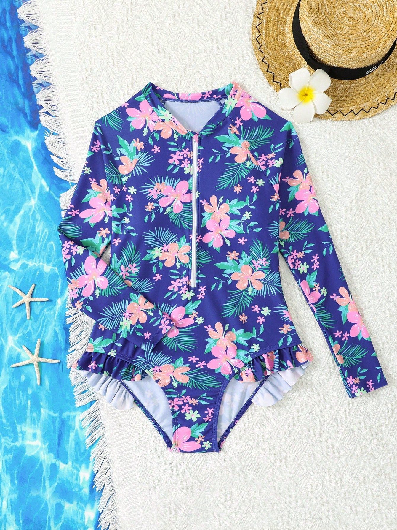 Girls one-piece swimsuit in blue with all-over leopard leaf print, ruffle detail, zipper front, high neck, and lined body for swimming and vacation.