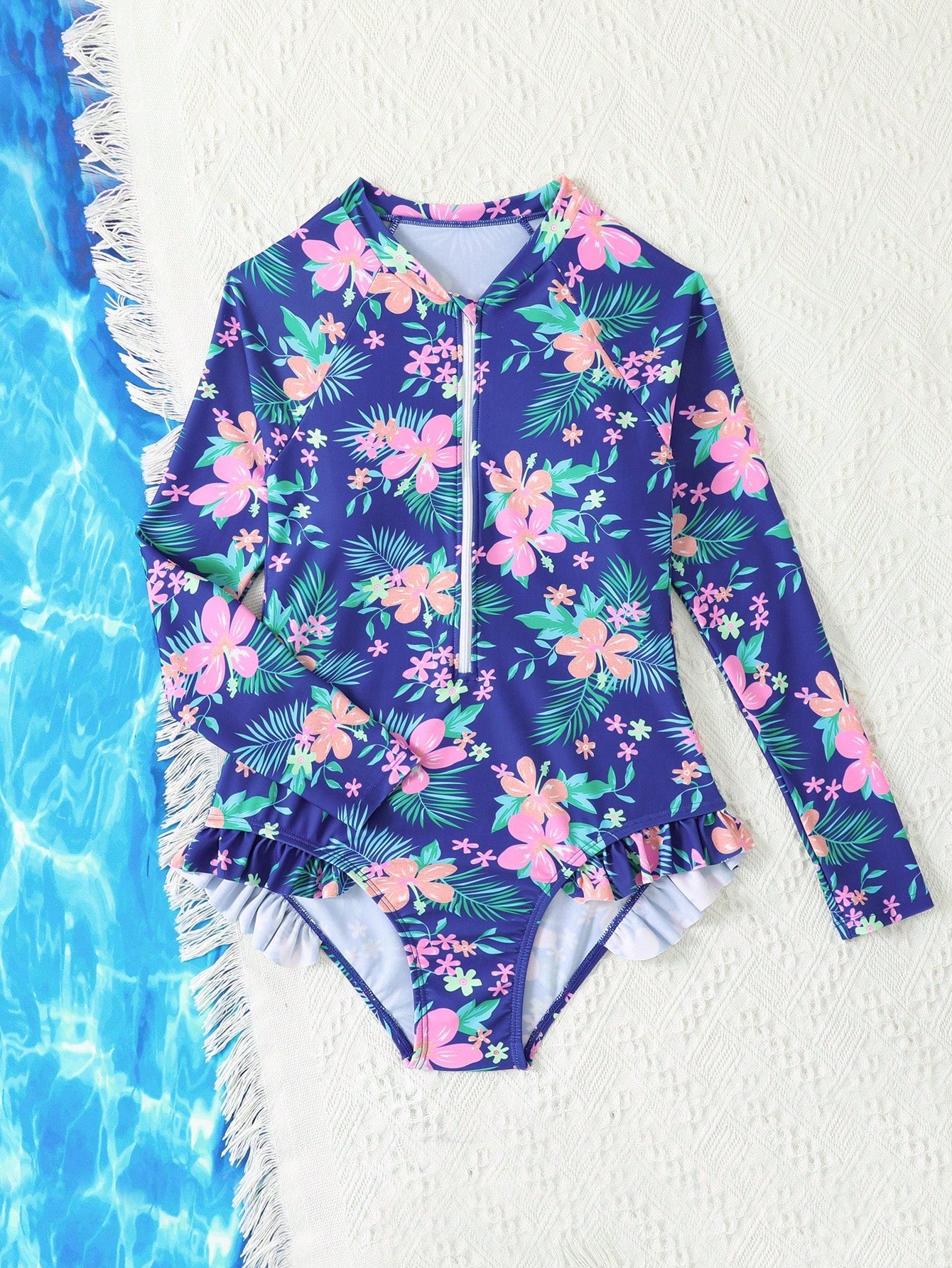 Girls one-piece swimsuit in blue with all-over leopard leaf print, ruffle detail, zipper front, high neck, and lined body for swimming and vacation.