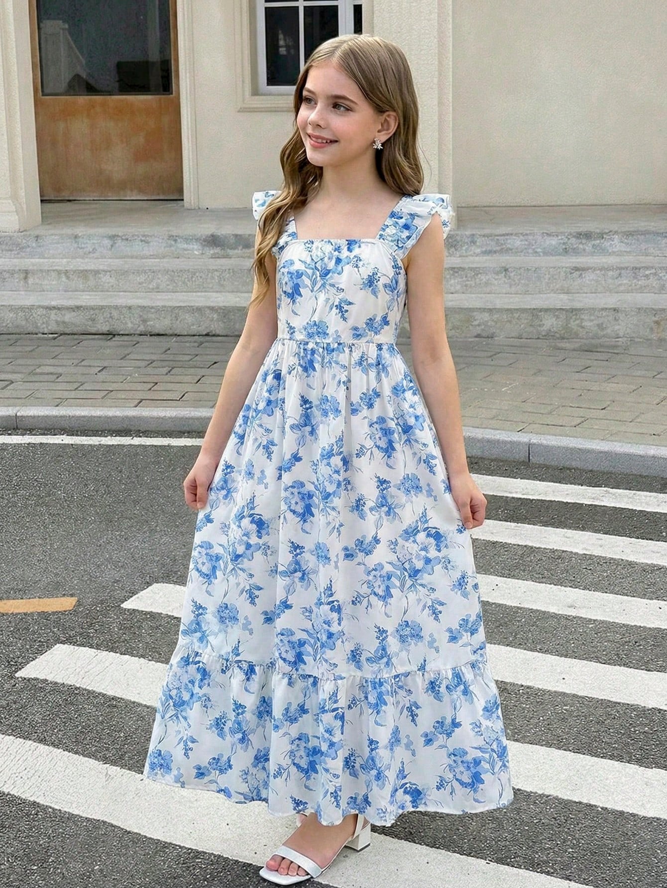 Tween girl multicolor floral vacation dress with square neck, ruffle details, shirred bodice, sleeveless A-line shape, high waist, and flounce hem.