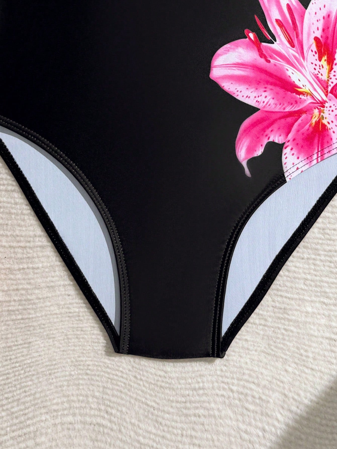 Tween girls one-piece swimsuit with a floral plant print, spaghetti straps, and a mid-waist fit in black.