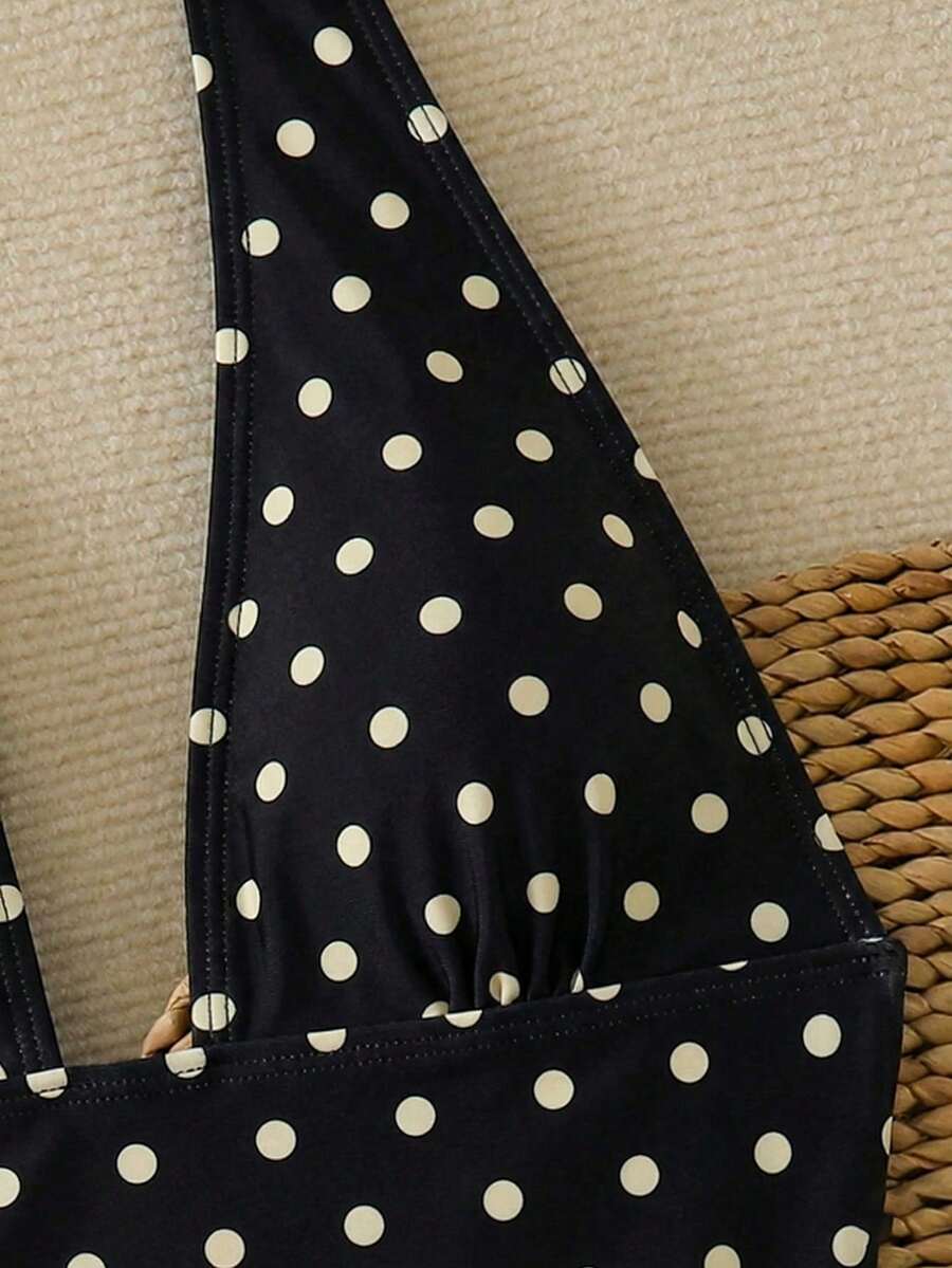 Women's apricot polka dot two-piece swimsuit featuring an asymmetrical halter backless top with knot tie detail and high-waisted bottoms.